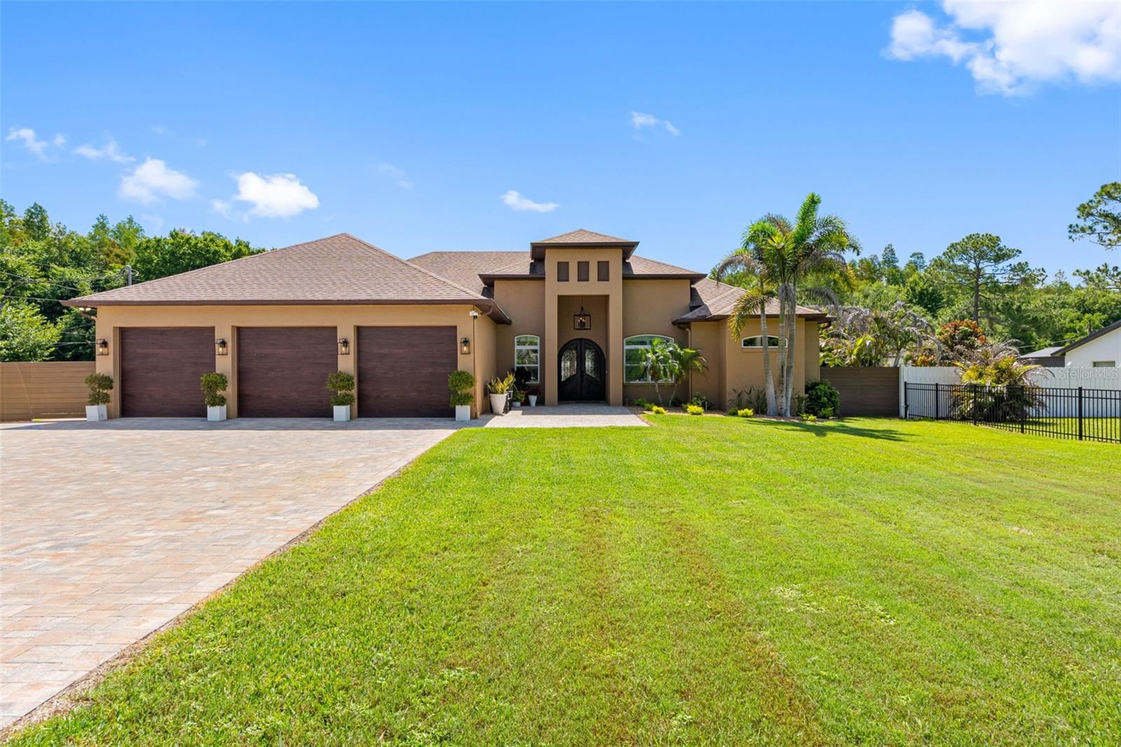 Nestled in one of Lutz's most desirable locations, this stunning custom-built estate offers the perfect blend of luxury, comfort, and convenience. Situated just minutes from St. Joseph's Hospital North, Downtown Tampa, the Veterans Expressway, and I-275, this exceptional residence features 4 bedrooms, 3 full baths, 1 half bath, a bonus room, and a spacious 3-car garage.

From the moment you arrive, the curb appeal is undeniable. The property is fully enclosed with elegant iron fencing, electric entry gates, block side fencing, rear electric gates, lush professional landscaping, irrigation, and an expanded paver driveway that creates a grand first impression.

Step through the impressive 96-inch custom front door with wrought iron detailing and tempered rain glass into a thoughtfully designed interior featuring soaring 10-foot ceilings, crown molding, porcelain tile throughout the main living areas, and a desirable split-bedroom floor plan. The formal living and dining rooms provide elegant entertaining spaces, while the spacious family room seamlessly connects to the heart of the home—the chef's kitchen.

Designed for both everyday living and entertaining, the custom kitchen showcases premium GE Monogram appliances, including a 48-inch side-by-side refrigerator, 48-inch gas range with double ovens, microwave, dishwasher, custom 48-inch maple hood, shaker cabinetry with LED lighting, pull-out shelving, Level 3 quartz countertops and backsplash, a massive 10-foot island with additional storage, and a walk-in pantry.

The luxurious primary suite offers two custom walk-in closets with built-in cabinetry and a spa-inspired bath featuring marble countertops, a freestanding acrylic soaking tub, oversized walk-in shower with porcelain tile and marble flooring, and a private water closet.

Additional interior features include a well-appointed laundry room with LG front-load washer and dryer, quartz counters, undermount sink, butcher block folding station, custom mudroom with built-in storage and seating, surround sound, plantation shutters, motorized roller shades, blackout shades in the primary suite, custom closet systems throughout, tankless water heaters, security system, three HVAC units, spray foam insulation, and an elegant red oak staircase with iron railings leading to the bonus room.

The backyard is truly a private resort. Enjoy year-round outdoor living with a heated saltwater pool featuring a waterfall, oversized screened enclosure, expansive paver lanai, and a fully equipped outdoor kitchen complete with a Blaze gas grill, Summit beverage cooler, stainless steel vent hood, sink, generous prep space, pine ceiling accents, and dual ceiling fans.

Additional upgrades include new insulated HP Low-E vinyl windows and doors, county water, septic system, electric fireplace, and countless custom finishes throughout.
In-law suite fully permitted with its own address.

    770sq" of living space features, 10ft ceilings,1 bedroom, walk in closet, bathroom with large shower, laundry closet and full kitchen with refrigerator, range and microwave. Large living/dining area with its own entrance. Tile flooring, own tankless water heater, septic system and ac unit. 

This one-of-a-kind Lutz estate offers exceptional craftsmanship, luxury upgrades, and resort-style living both inside and out. A rare opportunity to own a truly turnkey custom home in an unbeatable location.