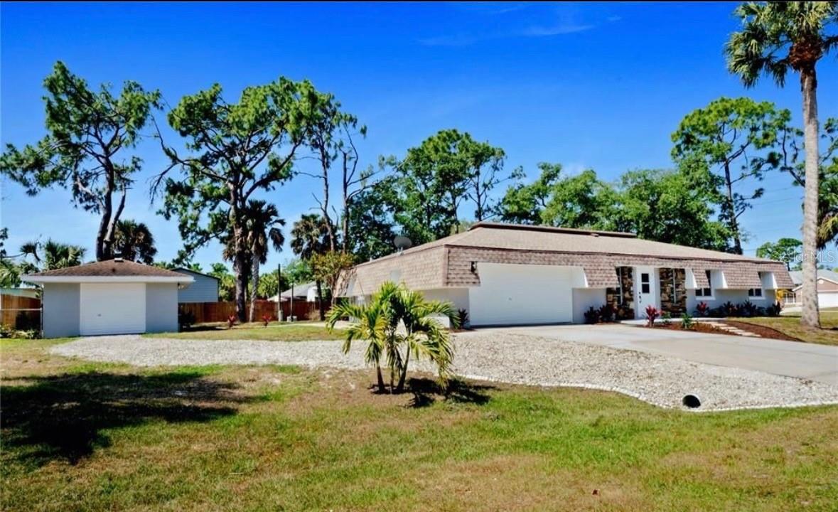 This recently renovated 3-bedroom, 2.5-bath pool home pairs modern finishes with the space and charm of an established neighborhood. Inside, a spacious living and dining area is finished in soft neutral tones, tall baseboards, and durable laminate flooring that continues through the bedrooms for a cohesive, refined look. The upgraded kitchen is designed for both everyday living and entertaining, featuring bright shaker cabinetry, granite countertops, stainless steel appliances, a classic subway-tile backsplash, and open shelving that frames the window and fills the space with natural light. The private primary suite offers a generous bedroom, double closets, and a stylish en-suite bath with a fully tiled walk-in shower and striking matte fixtures. Two additional bedrooms share an updated hall bath, and a convenient half bath adds flexibility for guests. Step outside to the oversized screened pool enclosure and expansive backyard—ideal for relaxing, grilling, and enjoying Florida living year-round. This home features 2-car attached garage plus a 1-car detached garage—ideal for a workshop or potential conversion into a guest suite.