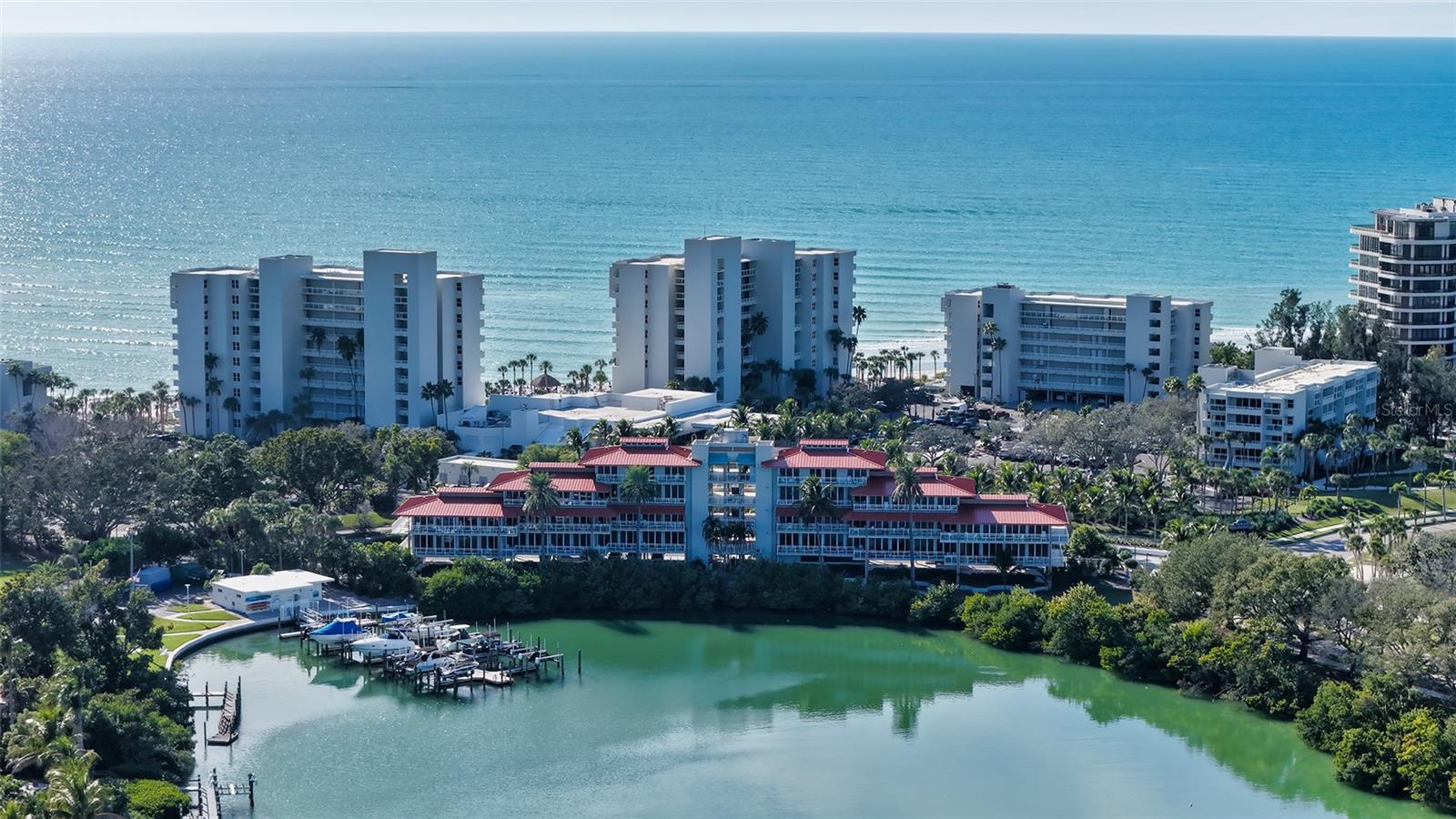 This beautifully remodeled Junior Suite captures serene lagoon views while offering excellent income potential through the established hotel rental program. Hurricane-impact sliders frame the space and open to a private terrace with glass railing, allowing uninterrupted views across the tropical lagoon setting. Sold fully furnished, this residence is truly turnkey, blending personal enjoyment with resort-style investment appeal. Inside, soaring 10’ ceilings enhance the sense of space and comfort, complemented by faux wood tile floors, crown molding and warm wood accents with shiplap detailing that add texture and character. A quaint dining area features a rich wood accent wall, creating a cozy yet refined atmosphere. The kitchen is thoughtfully appointed with stone countertops, white cabinetry with glass panel accents, stainless steel appliances and a striking tile backsplash that adds visual interest without overpowering the space. The spa-inspired bath continues the elevated feel, finished with shiplap walls, dual vanities and a walk-in glass shower adorned with gorgeous tilework. Every detail has been considered to create a polished, welcoming retreat for guests and owners alike. As part of the hotel program, ownership includes access to the exclusive 410-acre Longboat Key Club. Enjoy 5 distinctive restaurants, 45 holes of championship golf, the renowned Tennis Gardens, spa and fitness facilities, a private white-sand beach with attentive service, and a full-service marina, all proudly recognized with the AAA Four-Diamond Award.