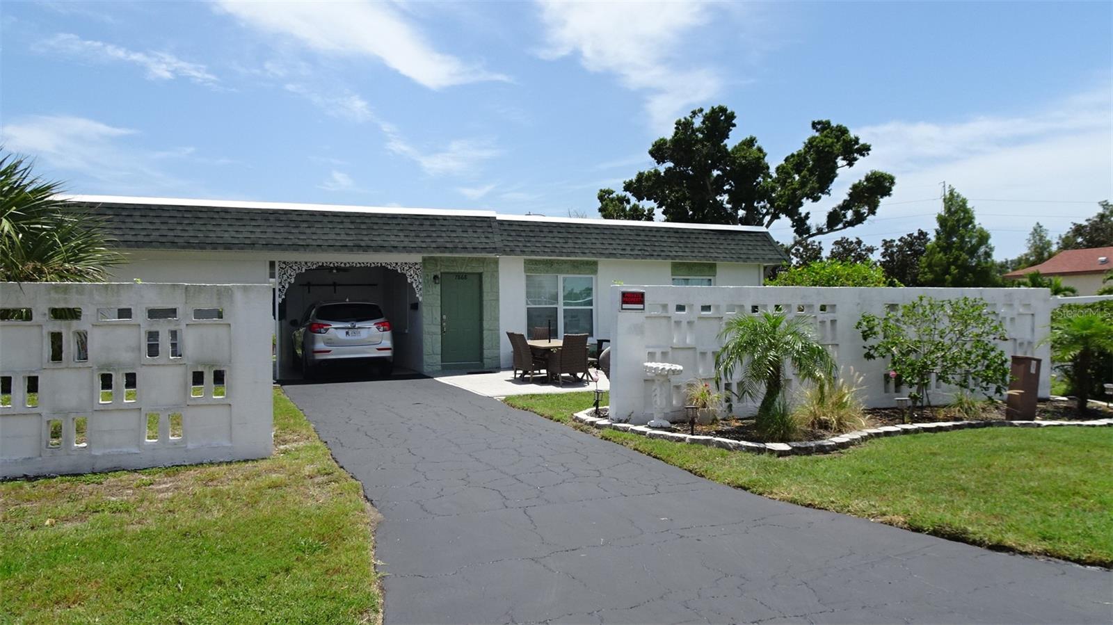 Welcome to your quiet Florida oasis in Tyrone Villas! Discover this hidden gem—a beautifully renovated, move-in-ready 2-bedroom, 1-bathroom corner villa offering the serene feel of standalone living with no shared walls. Situated in a highly desirable 55+ community, this charming one-story home immediately impresses with an expansive lot featuring a large front yard, an extra-long driveway, and an attached, covered carport for year-round shaded parking. Relax or entertain in ultimate privacy on your personal front yard patio, surrounded by a meticulously manicured lawn. Step inside to a light-filled living area showcasing $45,000 in recent premium upgrades, including new flooring, a completely remodeled bathroom, fresh paint, modern appliances, and elegant plantation shutters on all windows. The kitchen has granite countertops, new stove and refrigerator and a comfortable eat-in space. The primary suite easily accommodates a king-sized bed. A highly versatile second bedroom functions perfectly as a den, guest space, or home office. Designed for absolute convenience, the home features a dedicated 8 ft X 5 ft storage room right off the carport. Positioned directly behind it is a separate laundry room with rear yard access, equipped with full-size stackable washer and dryer. For added peace of mind, the villa features efficient gas heat, stove, and a gas hot water heater, a durable roof replaced in 2025 (maintained by the association), updated windows, and new sliding glass doors. Best of all, this property experienced no flooding or damage from the 2024 hurricanes. Tyrone Villas is a quiet, beautifully maintained, pet-free, and non-leasing community. Residents enjoy fantastic amenities just steps from their front door, including a heated swimming pool, clubhouse with a library, small gym/exercise equipment, and shuffleboard courts. The low monthly association fee conveniently covers water, sewer, trash, roof, and exterior maintenance. Perfectly situated in the prime Tyrone area, you are minutes away from Tyrone Mall, exceptional dining, shopping, banking, and the Bay Pines VA Hospital. Outdoor and city lovers will appreciate the close proximity to the Pinellas Trail, world-famous sugar sand Gulf beaches, and vibrant Downtown St. Pete and the Pier. With easy access to Clearwater and Tampa International Airport, this villa truly offers the perfect balance of peaceful retirement living and urban convenience. Schedule your private showing today and step into your Florida forever home! Can be sold Furnished or unfurnished.
