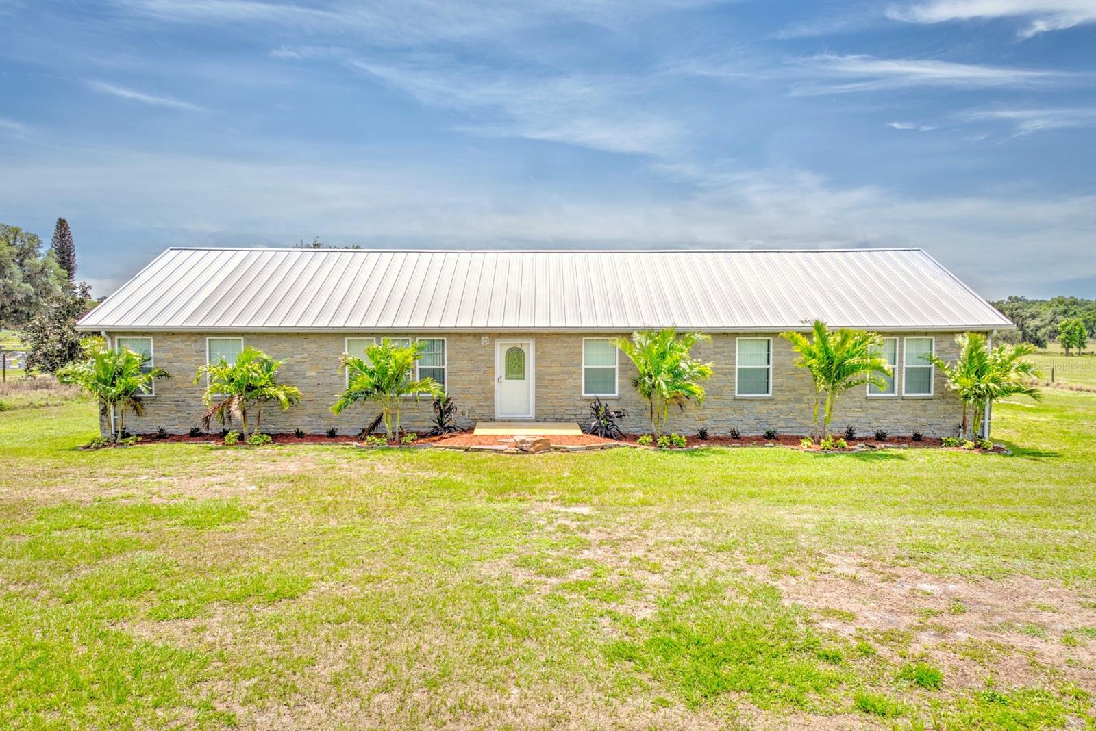 This charming ranch home presents comfortable efficient layout, generous rooms, and quality finishes that create a welcoming residential environment. The open concept living area creates a seamless flow between spaces, enhanced by luxury vinyl plank flooring that extends throughout the main areas. The kitchen features stainless steel appliances. Comfortable carpeting is installed in the primary bedroom, guest bedrooms, and home office. Practical amenities include a inside laundry room and new HVAC system. The screened lanai offers protected outdoor living space where you can relax while taking in tranquil pasture views that stretch across the property's expansive 3.36 acres. Durable metal roofing tops the home, ensuring long-lasting protection with minimal maintenance. Schedule your tour today and experience firsthand what makes this home the ideal place to call home.This is a Fannie Mae HomePath property. First Time Buyers, complete the HomePath Ready Buyer homeownership course on Homepath. Attach certificate to offer up to 3% closing cost assistance. Check HomePath for more details. Restrictions apply.