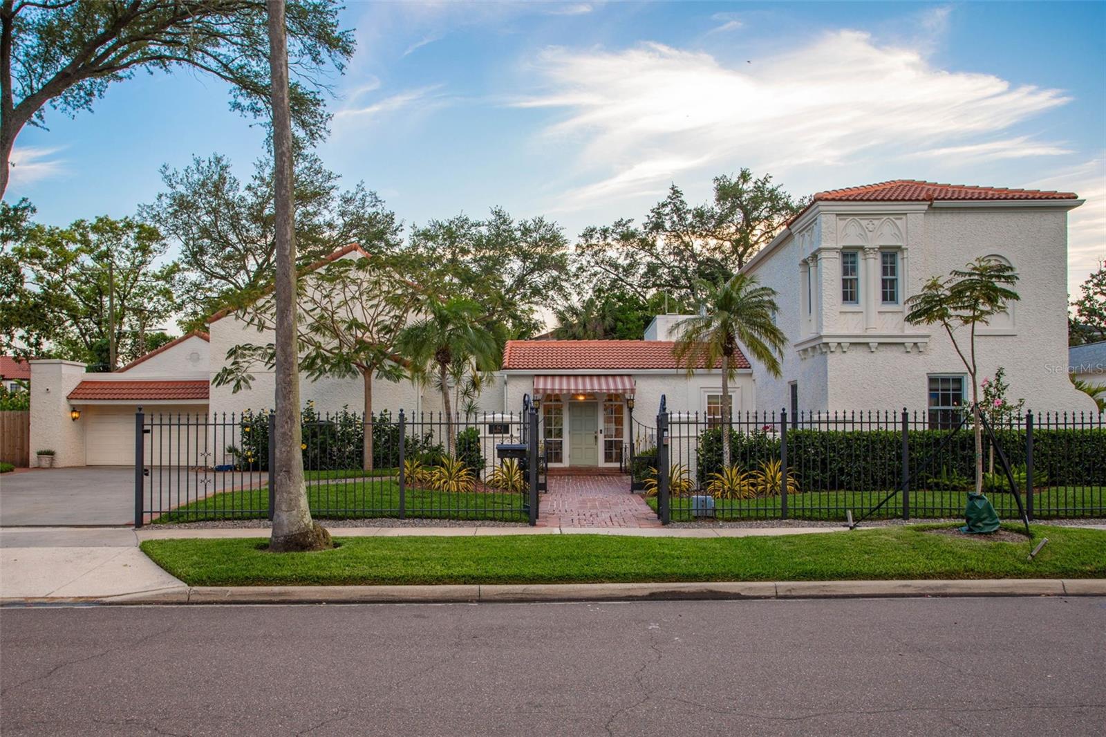 This historic Mediterranean masterpiece on Davis Islands offers luxury living on a rare double lot, privately tucked behind lush landscaping, privacy fencing, and a gated entry. Thoughtfully renovated, the residence features six bedrooms and five-and-a-half bathrooms designed for both entertaining and everyday comfort. The first level showcases multiple living areas ideal for hosting family and friends, anchored by a show-stopping gourmet kitchen with custom cabinetry, an oversized 13’+ center island, multiple sinks, floating shelves, elegant brass fixtures, and a Waterdrop filtration system. Premium appliances include an iLVE 48-inch gas range, GE Monogram 48-inch refrigerator, Bosch dishwasher, Fisher & Paykel dishwasher drawer, microwave drawer, large wine refrigerator, and an additional full-size backup refrigerator. A well-appointed butler’s pantry completes the space with a cocktail and coffee station, sink, ice maker, mini refrigerator, and abundant storage. The first-floor primary suite is a true private retreat featuring vaulted ceilings, two walk-in closets, and direct access to the serene backyard and heated pool. The spa-inspired primary bathroom offers a luxurious soaking tub, dual vanities with a dedicated makeup station, a water closet, and an expansive walk-in shower. Upstairs, three separate wings provide additional bedrooms, bathrooms, and flexible office or bonus spaces, allowing for exceptional versatility and privacy. Outdoors, the backyard unfolds as a tropical oasis with mature landscaping, a heated pool, BBQ station, pool bath, integrated sound system, and custom lighting; creating an ideal setting for year-round enjoyment. Additional highlights include a two-car garage accommodating full-size SUVs, a large laundry room, abundant closet and storage space, a new roof and gutters, Sonos sound system throughout the home and outdoors, security system, automatic driveway gate, gas fireplace, Generac generator, tankless water heaters, reclaimed irrigation, a storage shed, and professionally installed flood barrier and drainage systems. The property is located within highly regarded school districts including Gorrie Elementary, Wilson Middle School, and Plant High School. Enjoy the serene Davis Islands lifestyle from this special home. Private showings only; please contact the listing broker to schedule a tour.