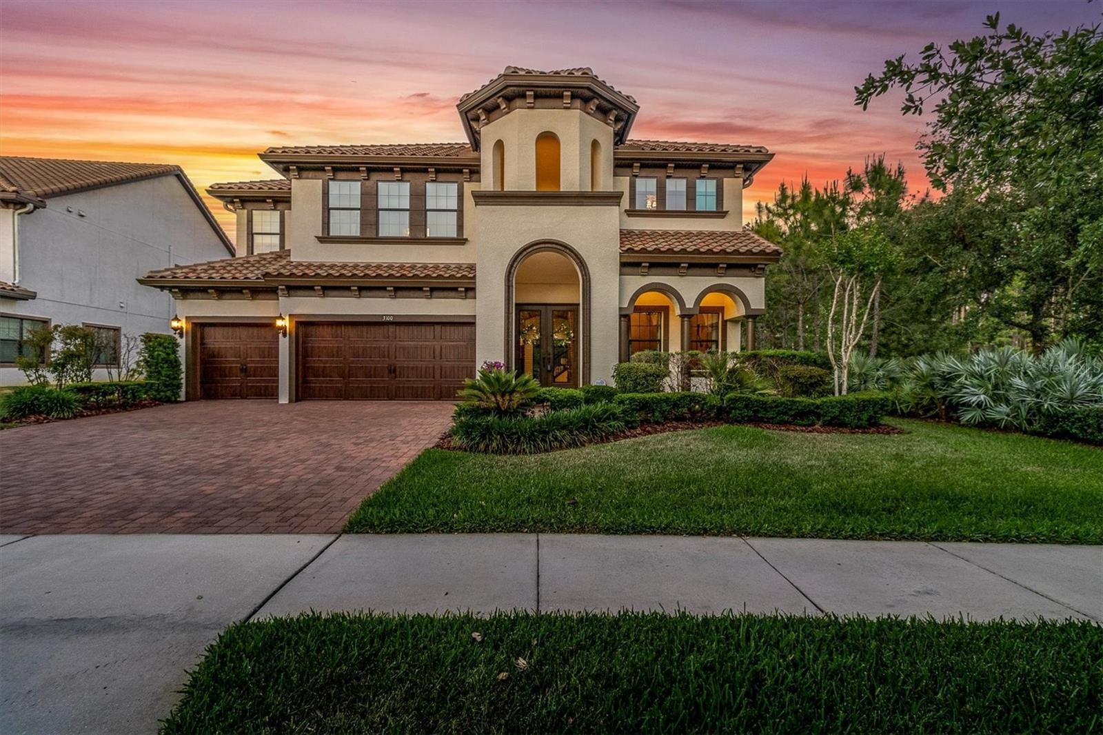 CAPTIVATING LUXURY ESTATE HOME ON A WRAP AROUND CONSERVATION LOT IN THE PREMIER LIFESTYLE COMMUNITY OF STARKEY RANCH. Magnificent in both scale and luxury, this beautifully appointed Homes By WestBay Granada II spans 4938 sqft on 2 stories possessing 6 br, 6 ba, office, movie theater, bonus rm & 3 car garage. The remarkable floor plan is custom-built w/ fine craftsmanship & a sociable open floor plan privately situated on a corner lot w/ stunning views of pond & trees. Noteworthy upgrades include wood-look tile on main floor, Elegant Fieldstone Walls, custom window treatments, freshly painted Sherwin Williams White Duck interior, Carrier Gold 18 SEER AC w/ Infinity Air Purifier & designer lighting.  The newly painted Mediterranean Exterior has exceptional curb appeal thanks to Rotunda, tile roof, widened paver driveway & manicured landscaping. Decorative glass inlay front door greets guests & the Mediterranean aesthetic blends seamlessly inside. To the right, double doors lead to the dedicated office. A full bath is close by. The exquisite detail of the stone walls surrounding the formal dining rm chandelier invites long meals shared w/ family & friends. An impressive Gourmet chef’s kitchen beckons the culinary enthusiast. Stylish Antique Vanilla Raised Panel Maple Wood cabinets w/ crown & soft close are complemented by oil rubbed bronze hardware, real brick backsplash & gleaming quartz counters illuminated by under cabinet lighting. Appliances include 19.8 Refrigerator, 19.8 freezer, built in oven & microwave, gas cooktop, new dishwasher, & stylish copper hood. A spacious island w/ knee-wall cabinets & pendent lights is the perfect place to gather while a breakfast nook offers more space to entertain. A butlers pantry complete w/ wine fridge is adjacent to the spacious walk in pantry w/ custom built-ins. The Grand Room features attractive ceiling fan, a breathtaking view of conservation & pool, stone accent wall, space to support any furniture configuration & storage closet.  Double doors lead to a secluded 1st story Primary retreat w/ stone framed sitting area, ceiling fan, can lights & custom panels + his & hers walk-in closets. Luxurious Ensuite offers frameless glass walk-in shower, dual his & hers sinks w/ quartz counters & garden tub. Ascend the Wrought iron staircase to the 2nd story. Bonus room + loft offer functional space leading to a delightful balcony w/ stunning views of the nature preserve. Enjoy time watching your favorite movie in the home theater. Br 2 w/ walk-in closet is close to ba 3. Spacious br 3 and 4 each offer walk-in closet and share a Jack & Jill bath. Br 5 & 6 also share Jack & Jill bath 5. The laundry room is conveniently located on the 2nd fl w/ cabinets, quartz counters & sink. Memories will be made in this secluded outdoor living masterpiece! Cool travertine pavers frame the heated saltwater pool w/ PebbleTec, water feature, LED lights & sunshelf w/ unobstructed views of the conservation via the panoramic screen. A full pool bath is located outside. Dine alfresco under a shaded space w/ ceiling fan. Attractive outdoor kitchen features grill, hood, refrigerator & sink. Gather near the custom stone outdoor fireplace in the evening & enjoy the wildlife.  An adjacent green space affords more space to play.  The Starkey Ranch community offers Starkey K-8 Magnet School, 3 pools, parks, playgrounds & walking trails. Enjoy an effortless lifestyle in this exceptional home. Schedule your private tour today.