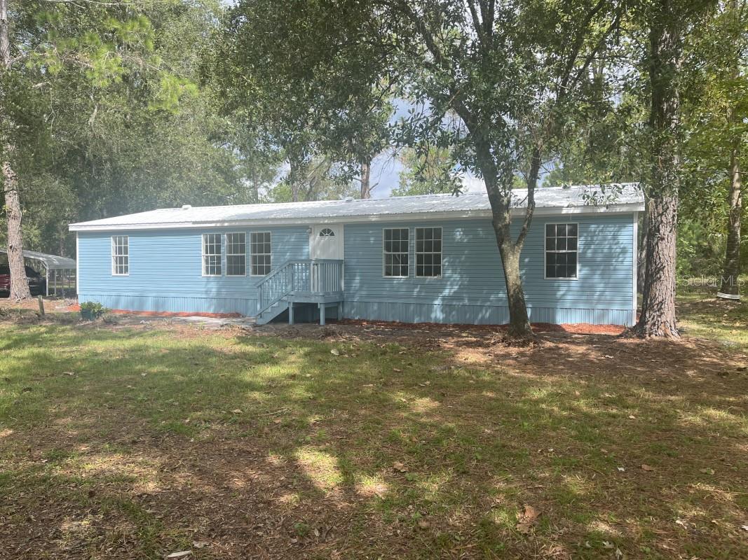 FULL REMODEL....this one is a must see with over 2 acres. The main house has a newer metal roof, brand new AC, new front steps, new kitchen with quartz counter tops, shaker cabinets and stainless appliances along with a wine/beverage fridge and new LED Lighting. The master bedroom has a big walk in closet plus large en suite bathroom that IS ALL BRAND NEW with a separate shower and tub and dual sink vanity. The whole house has brand new LVT flooring with a mold resistant padding installed underneath. The second bathroom has a shower with glass door along with a new vanity, mirror, LED lighting, fan and toilet. Everything is new. All bedrooms have new fans with lights and new shelving in closets. Brand new tankless water heater. All new interior/exterior doors and hardware. All new plumbing fixtures in kitchen and bathrooms. Also the foundation has been professionally leveled and tied down along with new underbelly and skirting. No problem passing an engineer inspection. Its all been done. New paint inside and out. You will also love the carport to park under and the storage shed for your items. property also has two small barns. One is a two horse and the other accommodates 3. Come make this one your home.