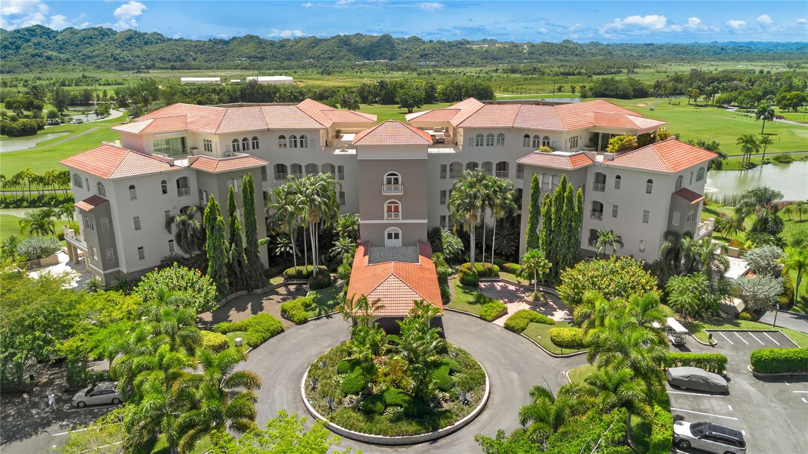 Nestled within the prestigious Ritz Carlton Reserve at Dorado Beach, a world renowned five-star resort, this exquisite ground floor 3 bedroom, 2-and-a-half-bathroom luxury condo in  Plantation Village II offers a seamless blend of sophistication and tropical elegance. With panoramic views of the resort’s award-winning golf courses from your own infinity pool, this fully furnished 2,719 square foot Ferrer model residence promises an unmatched lifestyle. 

Step inside to discover an expansive open concept living and dining area that reflects the vibrant hues of the Caribbean, creating a warm and inviting atmosphere. The spacious living room flows seamlessly into a gourmet kitchen, featuring high-end Kitchen Aid appliances, custom white lacquer cabinetry, and gleaming granite countertops. Stunning glass tile backsplashes add a touch of artistry, while the kitchen island serves as both a culinary workspace and an inviting gathering space, perfect for entertaining friends and family.  

Throw open the doors to your sprawling, meticulously designed terrace. The outdoor kitchen features specialized PVC lacquered weatherproof cabinetry, fully integrated Nexgrill gas grill and a TV to creating the ideal setting for alfresco gatherings. The bespoke 20 by 14-foot saltwater, temperature-controlled pool features mosaic hand tiling throughout. A serene retreat, surrounded by chic loungers, lush tropical landscaping, large industrial outdoor AC units, and fully extending electric awnings, ensures a perfect space for relaxation and entertaining day or night.

This well-appointed condo is designed as a tranquil retreat with closets outfitted by local woodworkers providing ample storage and versatility. The primary suite boasts a spa-worthy en-suite bathroom, complete with a double vanity, soaking tub, stone wall shower, and tranquil views of the green landscape surrounding it.

Additionally, the condo features a private laundry area equipped with a top-of-the-line washer and dryer for your convenience. The purchase includes a camera alarm system with 6 cameras and an industrial safe, your security is always guaranteed. In addition, this exceptional residence comes with rare-to-market, enclosed, climate-controlled garage and includes a lux Onward golf cart. Use it to explore the sprawling resort grounds and pristine beaches with ease. 

Residence 107 truly embodies the ultimate tropical lifestyle, where every detail has been meticulously curated for comfort and elegance, inviting you to indulge in the beauty and amenities of Dorado Beach, Puerto Rico.