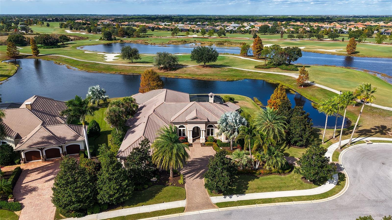 In exclusive gated Country Club East, this home sits on a rare .63-acre cul-de-sac waterfront lot. The stunning one-story, custom-built John Cannon home offers over 4,700 square feet of beautifully designed living space with an open floor plan and soaring ceilings. Travertine flooring flows throughout most of the main living areas, including a spacious living room with fireplace, an office, separate family room, and a formal dining room. Beautifully appointed kitchen with gas cooktop, island, pantry and separate breakfast area. An oversized bonus room is perfect as a game room, music room or future movie theater. Most rooms open to views of the oversized screened lanai and pool, (the spa and pool have separate controls for heating) showcasing serene water and golf course vistas. The thoughtfully designed split bedroom plan features an expansive primary suite with a luxurious bathroom, there are 3 large guest bedrooms with 2 en-suites. Impeccably maintained with numerous upgrades, including a whole-house generator, this exceptional home reflects outstanding quality throughout. Truly a must-see to fully appreciate. This Lakewood Ranch gated community boasts 3 community pools, fitness center, walking trails, clubhouse plus social events. The Lakewood Ranch Golf and Country Club membership is optional and available with access to 4 championship 18 hole golf courses, tennis and pickleball courts plus much more.