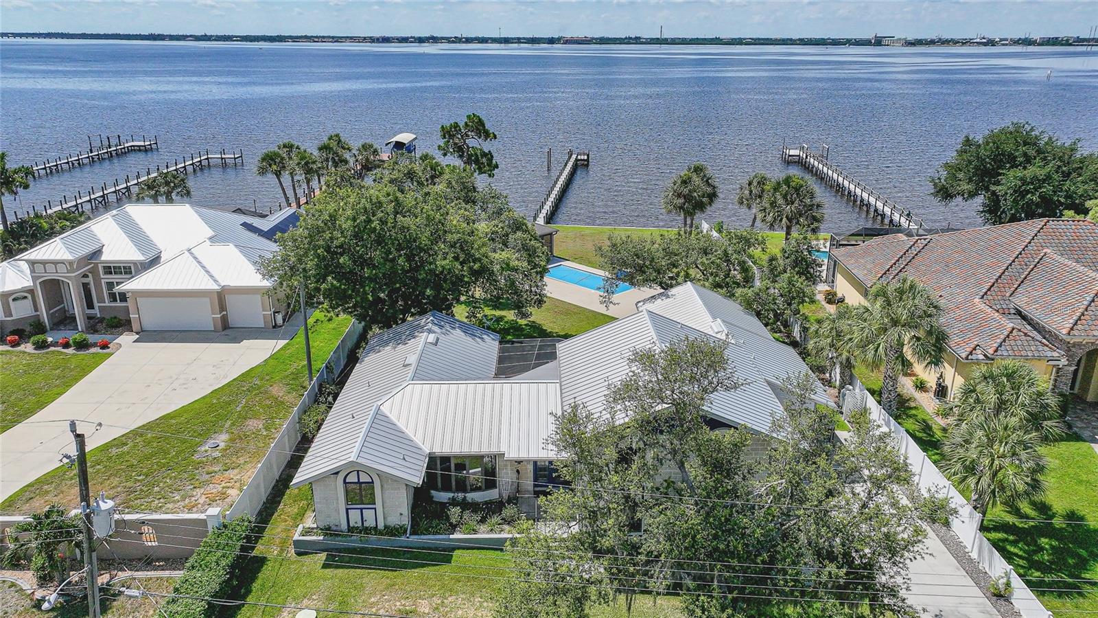 Virtually Staged. Experience exceptional waterfront living in this stunning Peace River Estate, offering 100 feet of direct waterfront frontage, breathtaking panoramic views of the Peace River and Charlotte Harbor, and a brand-new dock with electric and water service. Situated on nearly half an acre in the desirable Charlotte Shores community, this two-story residence combines luxury, comfort, and an unparalleled coastal lifestyle. 
Boasting over 3,000 square feet of living space, this meticulously maintained home features 3 bedrooms, 3 bathrooms, a 2-car garage, formal living and dining rooms, and a spacious family room designed to maximize the spectacular water views. Large windows and sliding glass doors throughout fill the home with natural light while showcasing the ever-changing waterfront scenery. 
The gourmet kitchen is a chef's dream, offering granite countertops, solid wood cabinetry, stainless steel appliances, a built-in oven, gas range with indoor grill, tile backsplash, center island with storage, breakfast bar, closet pantry, and a wet bar complete with a wine refrigerator—perfect for entertaining family and friends. 
Privately located on the second floor, the expansive primary suite encompasses over 500 square feet and serves as a true retreat. Enjoy stunning water views, dual walk-in closets, and a luxurious ensuite bath featuring dual vanities, a makeup station, bidet, private water closet, and an oversized walk-in shower with built-in seating. Two generously sized guest suites on the main floor each feature their own private bathrooms, ensuring comfort and privacy for visitors. 
Designed for year-round enjoyment, the outdoor living spaces are equally impressive. Relax on the screened lanai, take a swim in the heated saltwater pool, or unwind in the charming, screened poolside cabana. The fully fenced backyard provides privacy while offering endless opportunities to enjoy the Florida sunshine, launch a kayak or a boat, fish from your private dock, or simply take in the tranquil waterfront setting. 
Additional features include a 2022 metal roof, 2024 dock, whole-house water filtration system, 23KW whole-house generator with propane tanks, two gas fireplaces, 3-zone air conditioning, pool auto-fill and cover system, separate water meter for irrigation, dock and pool use, vinyl fencing, elegant tile and parquet flooring, and an irrigation system for easy maintenance. 
Ideally located just minutes from downtown Punta Gorda, Fishermen's Village, waterfront parks, walking and biking trails, shopping, dining, entertainment, and easy access to US-41 and I-75, this rare waterfront offering delivers the ultimate Southwest Florida lifestyle. Welcome home to your private coastal sanctuary.