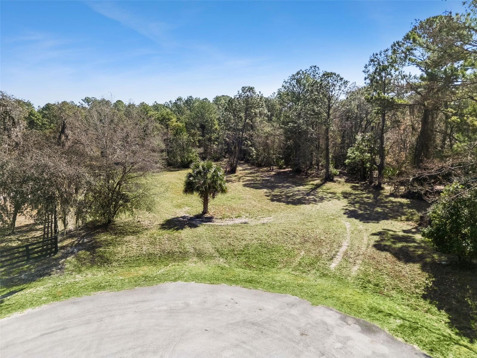 Welcome to an exceptional 5+ acre homesite on highly desirable Deer Park Ave in Eustis, one of the last remaining vacant tracts in an established enclave of estate-caliber custom residences, many exceeding $1,000,000 in value. This property offers the flexibility today’s buyers want: no HOA, no required timeframe to build, and bring your own builder. Deed restrictions maintain the integrity of the neighborhood, allowing one dwelling per lot with a minimum of 1,500 square feet of living area and a minimum two-car garage (attached or detached). Barns and stables are permitted. Manufactured homes are not allowed. Approximately 2.7 acres are protected by a conservation easement, preserving natural views and providing a habitat for native wildlife, leaving plenty of room to build. The property sits at the end of Deer Park Ave and directly borders the Lake Norris Conservation Area, managed by St. Johns River Water Management District. This adjacency ensures privacy and peace of mind, no future development behind you. Deer, turkey, and other wildlife are frequent visitors, enhancing the tranquil, Old Florida setting. Despite its private, rural atmosphere, the location remains highly convenient: 8 miles (12 minutes) to Publix shopping center, 9 miles (14 minutes) to US Hwy 441 with dining and retail,12 miles (20 minutes) to downtown Mount Dora. A rare opportunity to build your custom home in a protected natural setting while remaining close to everyday amenities. If you’ve been searching for acreage, privacy, and long-term value stability, this Deer Park Ave tract delivers. Lender & Builder referrals available.