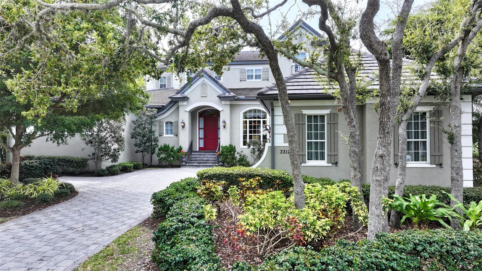 Unsurpassed island living on Longboat Key! This Home offers an easy blend of comfort, style, and privacy within the gates of Bay Isle Harborside. This Lakefront residence in Sabal Cove was masterfully designed by a revered architect and built to perfection by Anchor Builders.  Experience luxurious Florida living in this spacious lakefront Home with Southern exposure. This Home boasts 4 bedrooms en-suite, plus an office with 2 half baths  spanning over 5,150 sq. ft of  air conditioned living space, ensuring ample room for family and guests. The interior features an open floor plan, high ceilings, walls of glass doors, and windows that flood the Home with natural light, highlighting the finishes and attention to detail throughout. The Chef's Kitchen has high-end stainless-steel appliances, custom cabinetry, and a generous island, a culinary enthusiast's dream. This Home features an indoor-outdoor lifestyle, including a beautifully landscaped garden with a pool & spa, a covered patio with a fireplace, and an outdoor kitchen, perfect for entertaining or relaxation. 
This exquisitely detailed Home only gets better with a deeded beach access to the Bay Isles Beach Club. Minutes to enjoy a game of tennis in the renovated tennis center, a round of championship golf on the  45-hole golf course, or sail out of the Longboat Key Mooring marina, the 2nd largest marina on the West Coast of Florida. Enjoy the amenities of the nationally acclaimed Longboat Key Club or venture just a few minutes' drive to Publix, CVS, and the Post Office. It is a short drive to St. Armands Circle & Downtown Sarasota, where you'll experience endless fine dining, boutiques, theatre, Opera & art galleries. Leisure & luxury have never felt so good! 
Experience luxurious Florida living in this tropical home in paradise.