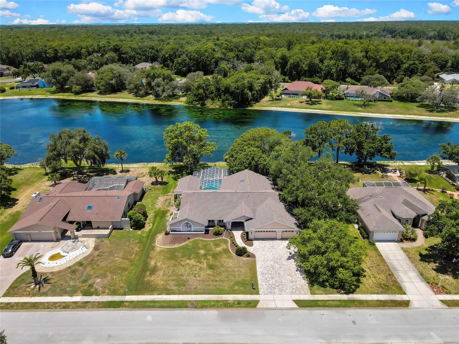 Welcome to one of Lake in the Woods' premier waterfront opportunities! Nestled within this highly sought-after gated community, this impressive 4-bedroom, 4-bath pool home offers an exceptional combination of space, privacy, and breathtaking lake views. Boasting 3,519 square feet of heated and cooled living area and an impressive 5,326 total square feet under roof, this residence was designed for comfortable everyday living and memorable entertaining. From the moment you arrive, you'll appreciate the home's commanding presence, mature landscaping, and picturesque setting overlooking the water. Inside, you'll find generously sized living spaces, soaring ceilings, and a flexible floor plan that provides room for everyone. Large windows and glass doors frame beautiful lake views throughout much of the home, bringing natural light and the beauty of the outdoors inside. The spacious kitchen with porcelain tile, multiple gathering areas, and expansive outdoor living spaces create the perfect setting for hosting family and friends. Step outside and discover your own private Florida retreat. The oversized in-ground pool, featuring a rare 10-foot deep end, overlooks the tranquil lake and provides the ideal backdrop for enjoying Florida's year-round sunshine. Whether you're relaxing poolside, enjoying morning coffee with water views, or entertaining guests in the outdoor living area, this home embraces the Florida lifestyle. As the day winds down, enjoy spectacular sunset reflections across the lake from your backyard oasis, where shimmering water views and peaceful surroundings create an unforgettable setting for relaxation and entertaining. Major updates include a roof installed in 2021 and an air conditioning system replaced in 2017, providing peace of mind for years to come. While the home presents an outstanding foundation and has been well cared for over the years, it also offers exciting opportunities for a new owner to add personal touches and maximize its full potential. Residents of Lake in the Woods enjoy the security of a gated community along with amenities that include tennis courts, pickleball courts, a playground, and community gathering areas, all while maintaining convenient access to shopping, dining, medical facilities, and the Gulf Coast's natural attractions. Waterfront homes of this size and caliber in Lake in the Woods are a rare find. If you've been searching for a spacious lakefront residence with a pool, incredible views, and unlimited potential, this may be the opportunity you've been waiting for.