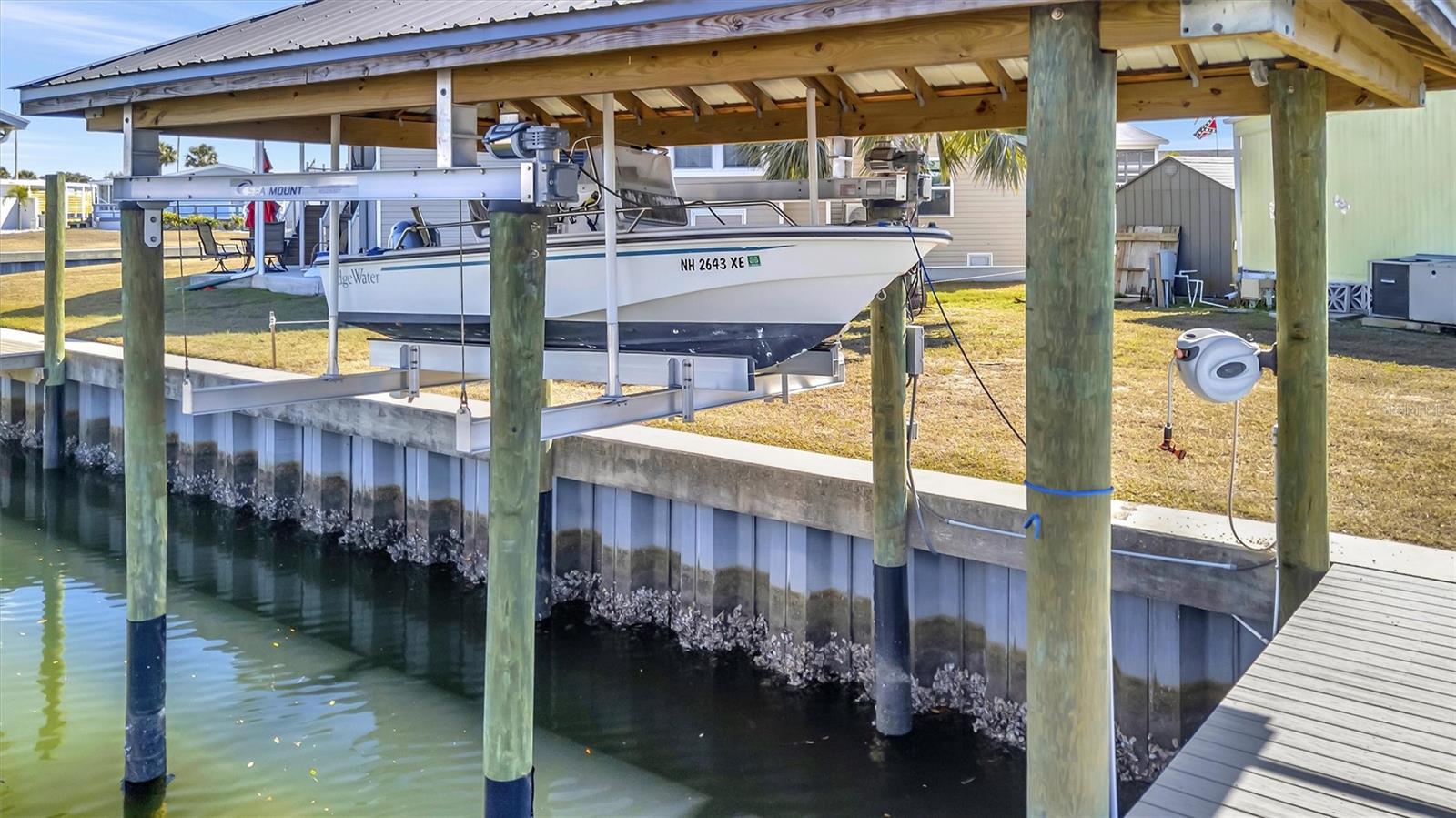 PRICE IMPROVEMENT! Waterfront Living at its core in Caribbean Isles Residential Cooperative, one of the most sought-after gated communities.  This property presents great access to Tampa Bay. Charming 2-bedroom, 2-bath Canal front home with a HUGE Metal-roof covered Boat Lift that has a large deck to enjoy the outdoors and marine life. Watch Mantee's and Dolphin play under your dock. Perfect for the fisherman or just to enjoy a late evening boat ride to watch the sunset. This home is Furnished and ready to move into. Very nice front Screened Porch area. Large Carport and out-building that has the Washer and Dryer. Caribbean Isles is a Very Active 55+ resort style community. The Clubhouse has a full commercial Kitchen that is used year-round for community events.  Caribbean Isles boasts gated access. Many amenities like Bocce Ball, Shuffleboard, Horseshoes and a Heated pool for the avid swimmer or for when the grandkids visit. The Clubhouse accommodates events like Dances, Bingo and other games. The annual Talent Show along with other live events like Comedians and plays. CI supports a large 10-acre storage area for your Boats or Travel Trailer or even the extra utility trailer. Prices range from $350 to $150 annually for your spot.  This community is very Financially sound, since its inception they have never had a Special Assessment. If relaxed lifestyle living is for you please request your tour. This community is a great place to call HOME!