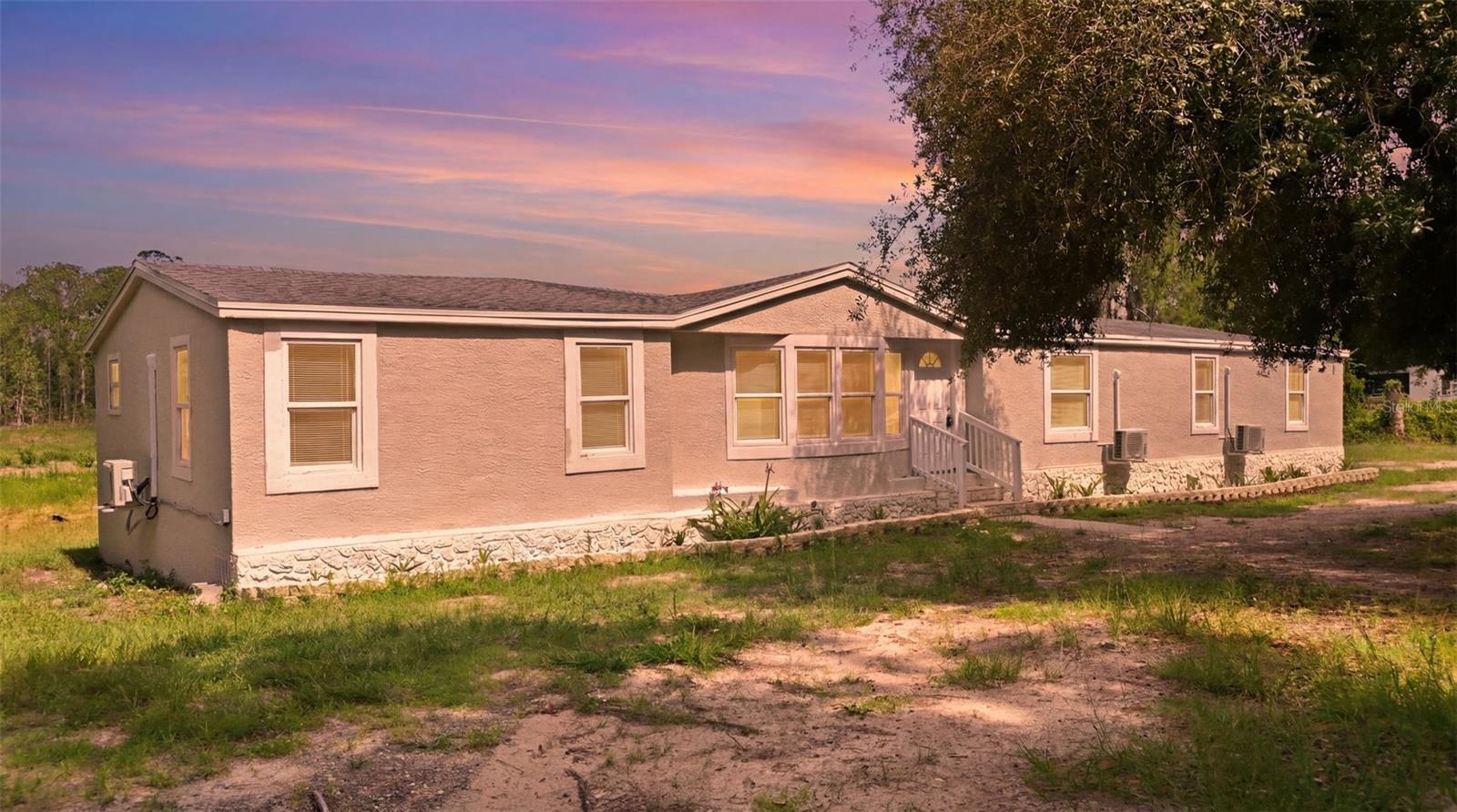 Experience the best of Florida living on 4.5+ secluded acres in unincorporated Lake County!!  With no HOA, wide-open space and total privacy, this property is perfect for anyone seeking room to breathe, grow, and enjoy the outdoors.  This spacious 4-bedroom, 2-bath manufactured home sits tucked away from the road and surrounded by mature trees, open land and a small private pond-- a peaceful natural backdrop for everyday living.  Recent improvements to the home include a brand-new roof, new hot water heater, and new A/C window units throughout the home, offering comfort and peace of mind.  inside the split floor plan features a generous living area, a large primary suite, and plenty of space for family and guests.  With acreage for animals, equipment, gardens or recreational toys, this property offers endless possibilities for the lifestyle you have been dreaming of.