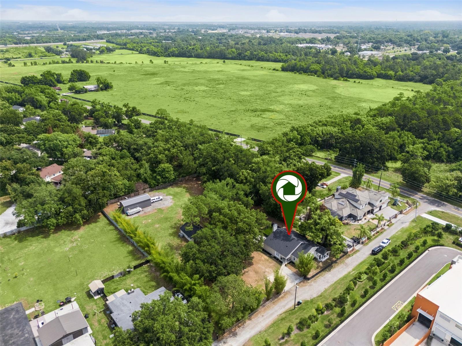 Situated on just under 1.5 ACRES, this beautifully updated & customized FENCED property offers the perfect blend of privacy, comfort, & flexibility with a rare opportunity to enjoy peaceful country-style living while remaining close to everyday conveniences. Mature landscaping & natural buffering create a private retreat-like setting, ideal for relaxing, entertaining, or enjoying the outdoors. This meticulously maintained 3-bedroom, 2.5-bath home has been extensively upgraded from head to toe including fresh interior & exterior paint, durable Hardie board siding, a new ROOF, paver patio, artificial turf dog run, whole house water filtration system & softener, new doors, & stylish finishes throughout. At the heart of the home, the upgraded kitchen showcases beautiful stone countertops, stainless appliances, including a convenient beverage fridge, soft-close drawers, & smart storage solutions including pull-out drawers & corner carousel organizers. The adjoining living & dining area flow seamlessly to the outdoor spaces, creating an ideal indoor-outdoor lifestyle. The living room is anchored by a charming WOOD-burning fireplace, creating a warm and inviting atmosphere. The spacious primary suite features dual vanities, ample storage, an oversized shower, & a walk-in closet with vanity. The additional two bedrooms are on the opposite side of the home, separated by a secondary full bath, which has been equally well appointed with a standalone soaking tub, shower, & dual sinks. One of the bedrooms features a unique loft space accessed by a built-in staircase, offering the perfect setup for a play area, reading nook, or additional storage. This space also leads to the attic. The third bedroom is ideally suited as a guest retreat, featuring FRENCH doors that open to its own covered porch—creating a peaceful space for visitors to relax & unwind. The thoughtfully designed laundry room features a stackable washer & dryer, extensive counter space, a utility sink, & a dedicated dog-washing station to help keep your pets clean after backyard play time! Outdoor amenities truly set this property apart. The expansive acreage provides endless possibilities for gardening, recreation, storage, or future expansion. Additional structures add tremendous versatility & value, including a large steel building (~20 X 45) on a concrete pad to house a BOAT/RV & a detached WORKSHOP (~18 X 18) that could easily function as a hobby space, home business, or potential future IN-LAW suite conversion. This property offers the ability to bring livestock, including horses, goats, chickens, & other animals, subject to Orange County allowances. HIGHLIGHTS: roof (2026), 15 foot vaulted ceilings, TILE flooring, custom trim and barn doors, AC (2022), water heater (2021), Hardie board siding (2024), full house remodel. Conveniently located just 10 minutes from charming downtown Winter Garden, residents can enjoy boutique shopping, local dining, the farmers market, entertainment, & scenic strolls along Plant Street and the West Orange Trail. The home is also in close proximity to the highly anticipated Dynasty Experience, a $1 billion sports development coming soon to Ocoee, adding investment appeal to this exceptional property. Easy access to interstate travel, golf courses, & world-renowned theme parks, don’t miss this RARE opportunity to live the country lifestyle in the heart of the action!