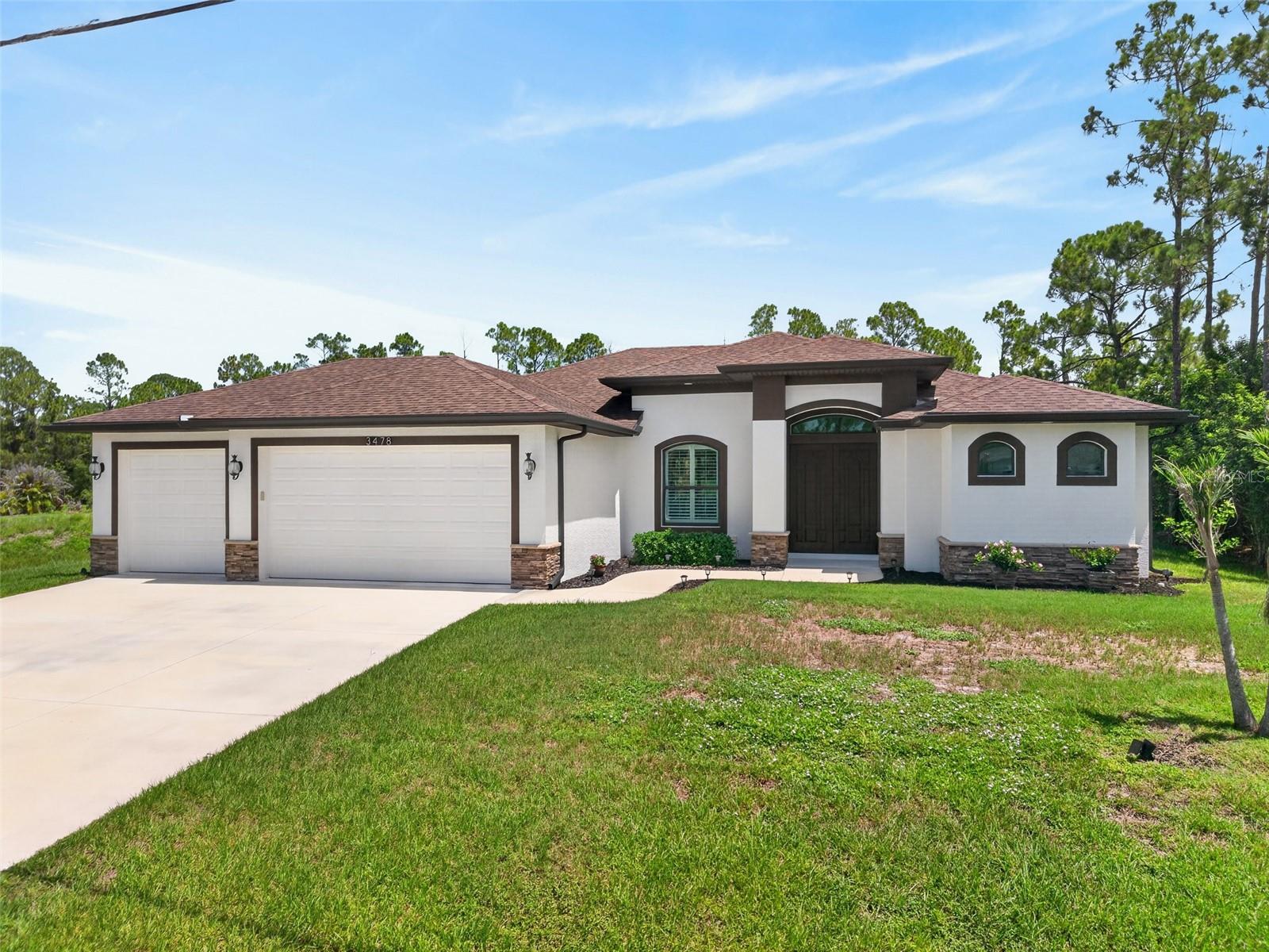 Exceptional custom-built home, completed in 2021, where quality craftsmanship and thoughtful design come together on an oversized lot in desirable North Port. Offering over 1,900 square feet of beautifully appointed living space, this 3-bedroom, 2-bath residence with an oversized 3-car garage has been meticulously maintained and showcases true pride in ownership.
The open-concept floor plan is designed for both everyday living and effortless entertaining, featuring ceramic tile flooring throughout, soaring ceilings, elegant crown molding, and lighted tray ceilings in the living room and primary suite. Hurricane-impact windows and impressive 8-foot solid wood doors add security and timeless appeal.
At the heart of the home is the gourmet kitchen, appointed with top-of-the-line stainless appliances, soft-close cabinetry, granite countertops, a tile backsplash, and an expansive island with a double stainless sink and breakfast bar—perfect for gathering with family and friends. Zero-corner slider from the living room and pocketing sliders from the kitchen and primary suite seamlessly connect the indoor living space to the screened lanai, creating the ideal Florida lifestyle.
The spacious primary suite is a private retreat featuring dual walk-in closets and a luxurious ensuite bath with dual vanities and an oversized walk-in tiled shower. A desirable split-bedroom floor plan provides privacy for guests offering a pocket slider to two generously sized guest bedrooms, each with walk-in closets, and a beautifully appointed full bath with a glass-enclosed shower.
Additional highlights include a convenient interior laundry room complete with cabinetry and a utility sink, an oversized 3-car garage with an epoxy-coated floor and abundant storage space, and a screened lanai featuring a prep station and sink—perfect for outdoor entertaining and weekend barbecues.
Step outside to enjoy the peaceful backyard setting, offering plenty of room to add your dream pool while still leaving ample space for furry friends to roam.
Ideally located with convenient access to I-75, this home is just minutes from shopping, restaurants, parks, schools, two hospitals and fire stations. Enjoy a short drive to Charlotte Town Center, Charlotte Harbor, historic downtown Punta Gorda, and the pristine Gulf beaches of Southwest Florida.
This move-in ready home combines luxury finishes, functional design, and an unbeatable location. Schedule your private showing today!