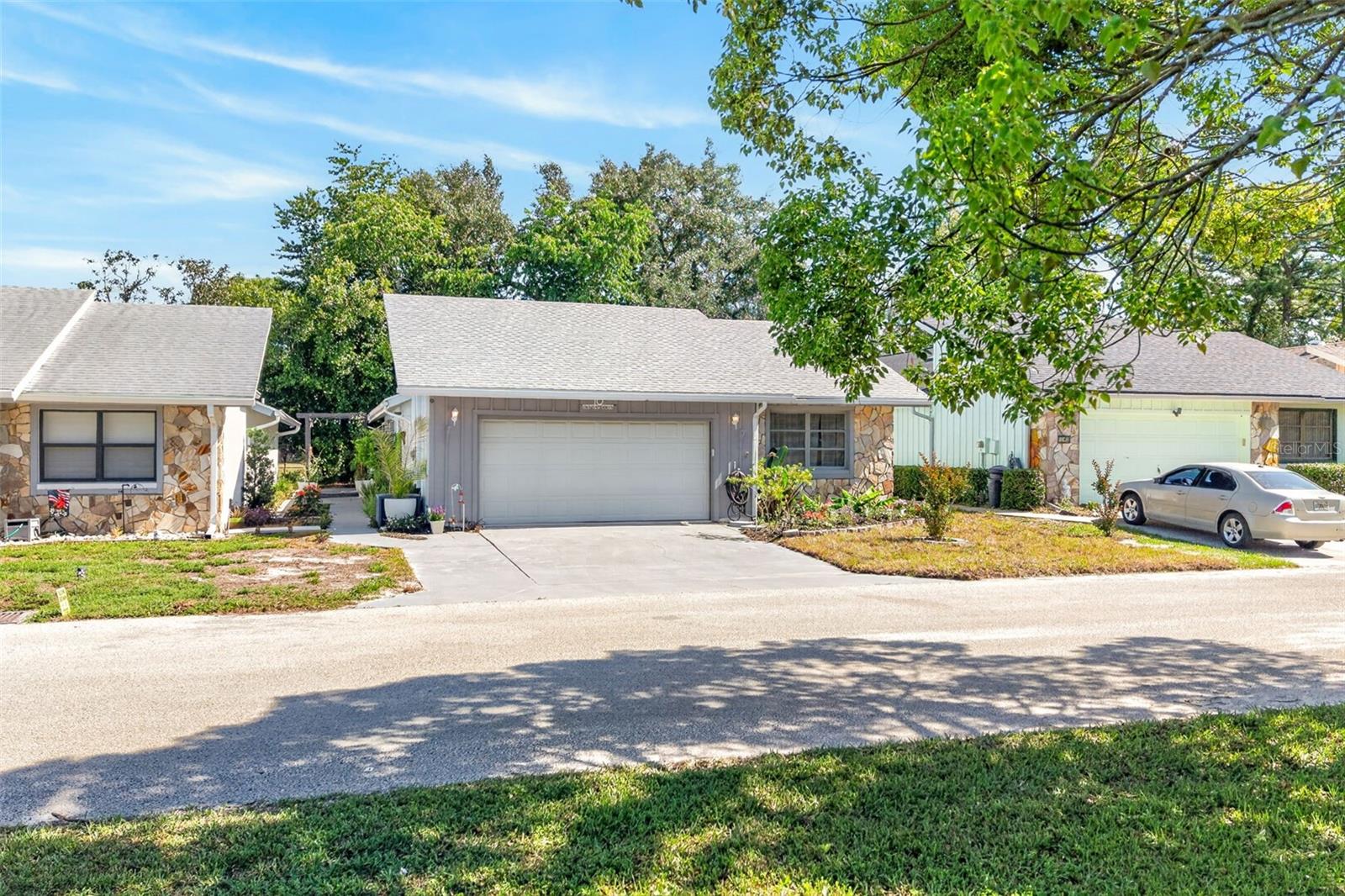Experience refined Florida living in this impeccably updated 2-bedroom, 2-bathroom, 2-car garage villa, gracefully positioned on the golf course within the sought after Cypress Village of Sugarmill Woods. A natural greenbelt creates a private, tranquil buffer, allowing you to enjoy the peaceful views without sacrificing seclusion. This residence showcased distinctive split floor plan with a separate entry, offering both privacy and architectural interest. Inside, you'll find a thoughtfully curated interior featuring fresh paint, updated vinyl flooring, and new ceiling fans throughout. The kitchen is appointed with stainless steel appliances and opens effortlessly into the main living area, where a stylish wet bar enhances the home's entertaining appeal. The bathrooms have been reimagined with solid surface counters, elegant beadboard detailing, and a custom barn door that adds both charm and sophistication. Recent upgrades include a 2022 roof, new garage door motor, and a Rain Bird irrigation system supporting the sod and lush landscaping. The garage offers added versatility with mounted TV-ideal for functional yet comfortable extension of home. Ideally located near Florida's renowned natural springs, perfect for manatee sightings, boating, and kayaking and just minutes from the Veterans Expressway for convenient access north. Residents of Sugarmill Woods enjoy an exceptional lifestyle with amenities including a clubhouse, fitness center, pickleball court and tennis courts, as well as RV and boat storage. A rare opportunity to own a beautifully upgraded villa that seamlessly blends comfort, privacy, and elevated living.