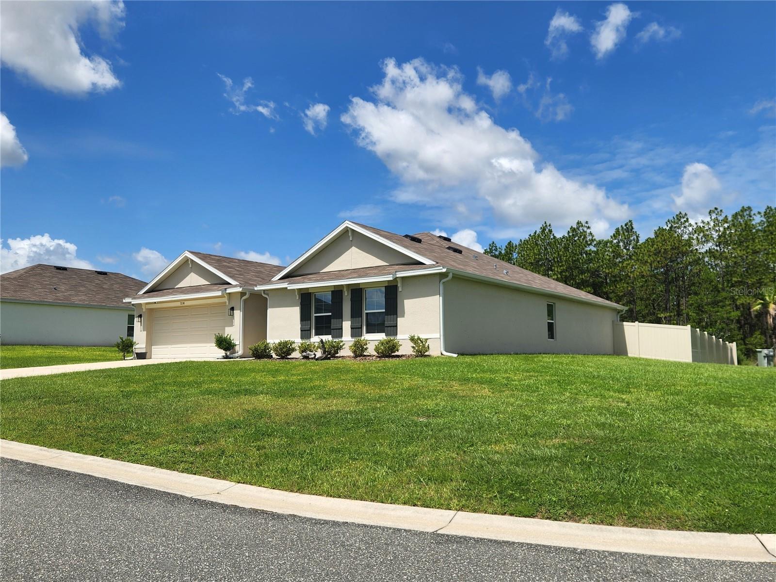 Nearly new and larger than most homes in the area, this 4 bedroom, 2 bath home offers a spacious 2319 sq ft floor plan on a desirable corner lot. The expansive great room flows seamlessly into the kitchen and dining area, creating the perfect space for everyday living and entertaining. The open-concept kitchen features granite countertops, stainless steel appliances, a pantry, and a convenient breakfast bar. Sliding glass doors from the dining area lead to a covered lanai with a roll-down shade, overlooking the privacy fenced backyard creating an ideal setting for relaxing, outdoor dining or entertaining. The generous primary suite is privately situated at the rear of the home and features a huge walk-in closet, dual vanities and a step-in shower. Additional highlights include a desirable split-bedroom floor plan and an inside laundry room with the washer and dryer included.