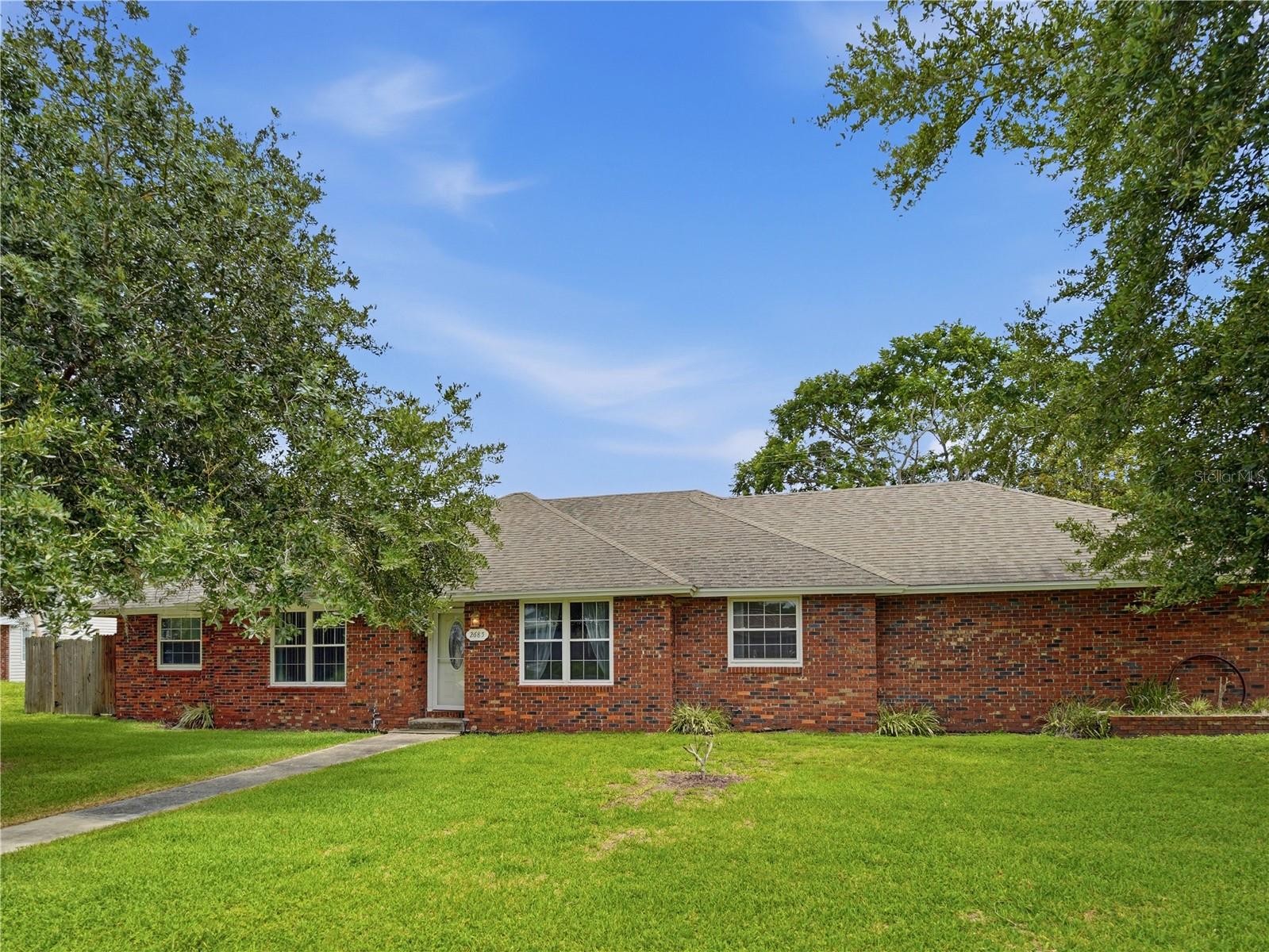 Just in time for summer, this centrally located 3-bedroom, 2-bath POOL home offers over 1,600 square feet of living space. The thoughtfully designed floor plan features a spacious living room, formal dining area, and a well-appointed kitchen complete with granite countertops, stainless steel appliances, an island bar with cooktop, and a large pantry/storage room. Tucked away from the main living spaces, the bedroom wing provides privacy and functionality. The generously sized primary suite features dual closets and an en-suite bathroom with a walk-in shower. Two additional bedrooms and a full guest bath offer comfortable accommodations for family and guests while providing flexibility to suit a variety of lifestyle needs. Two sets of French doors provide seamless access from the main living areas to the screened rear porch, overlooking the pool—an ideal setting for relaxing, entertaining, or enjoying warm summer days. An oversized two-car garage offers over 600 square feet of space, providing ample room for vehicles, storage, hobbies, or a workshop. With solid bones and endless potential, this home presents a wonderful opportunity to add your personal style and create the perfect Florida retreat.