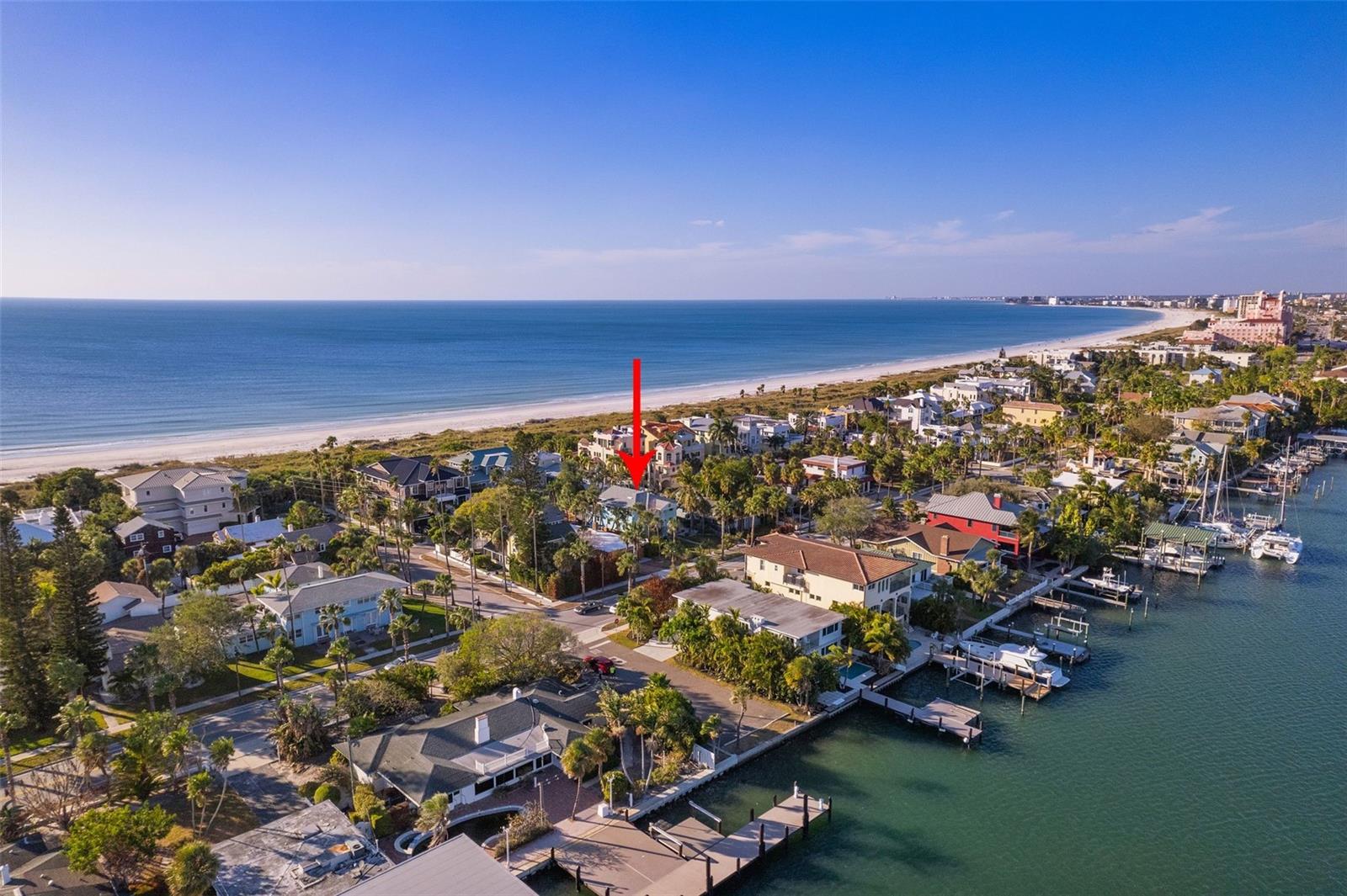 Walk the pristine shores of Pass-a-Grille, every day from your front door.   Come be captivated by the charm of this beach residence.  The top main floor, designed penthouse style, offers two bedrooms, two baths a gorgeous white kitchen with gray accents, a bright and vibrant living space with an open concept for dining.  The first floor is a full suite with another two bedrooms, two baths, it's own living room, laundry and a kitchen (minus the range).  This high-end property showcases meticulous architectural design and craftsmanship throughout.  Inside, you'll discover spacious and light-filled living areas adorned with high ceilings, large windows, and exquisite finishes. The open concept layouts seamlessly integrate the living, dining, and kitchen spaces, creating a perfect setting for entertaining If combined living is needed, no problem, if privacy or even a rental is desired, that's just as possible.  For multi-generational dwelling, this home is perfect.  Older relatives would not need to do a flight of stairs to be home.  The main living area of the home is an open floor plan.  The deep lot and back yard (Pass-a-Grille Way side) is the perfect space for adding a pool, outdoor kitchen or both.  The upstairs offers a serene balcony with gas grill and seating where you can relax and soak in the breathtaking views of the surrounding area or just enjoy the coastal breeze. Immediately inside the french doors off this balcony is a wet bar with a 54 bottle wine chiller -- perfect for cozy fresh air get togethers. All four bedrooms are en-suite allowing for a perfect guest experience. The primary bath is a spa retreat to be envied. Aside from the two car garage there is also a parking pad for extra cars - another rare and envious feature. Situated on the prestigious Pass-a-Grille peninsula, this home offers an unparalleled lifestyle. Residents will enjoy easy access to pristine white-sand beaches, vibrant local restaurants, boutique shops, and a variety of recreational activities. Whether it's a leisurely sunset stroll along the shore or indulging in the vibrant coastal culture, the possibilities are endless.
