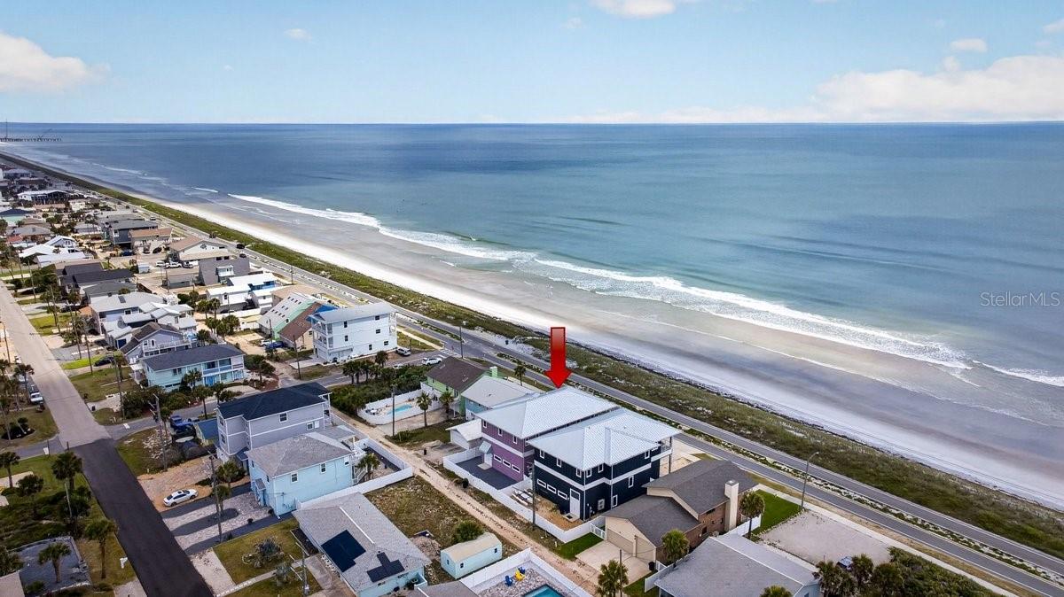 Direct oceanfront living meets newer construction and thoughtful upgrades along one of Flagler Beach's most desirable stretches of A1A. Built in 2022, this custom coastal home offers 4 bedrooms, 2 full baths, and 2 half baths across approximately 2,900 square feet, all positioned to capture panoramic Atlantic views and 100 feet of frontage. Constructed with insulated concrete forms (ICF), deep foundation pilings, and a metal roof, the home was designed for durability, efficiency, and long-term performance. Impact-rated windows and doors, along with spray foam insulation, enhance storm protection and energy efficiency. The main living level features an open-concept layout with elevated finishes throughout, including vaulted shiplap ceilings, stone countertops, and custom cabinetry.

The kitchen is equipped with Frigidaire Professional appliances, including a column refrigerator and freezer, induction range, and built-in features designed for both everyday living and entertaining. Sliding glass doors lead to an expansive ocean-facing balcony, creating a seamless indoor-outdoor connection.

The primary suite is positioned upstairs to take full advantage of the views, offering a spacious layout with a walk-in closet and a well-appointed bath with dual vanities and a walk-in shower. Additional bedrooms provide flexibility for guests, a home office, or secondary living space.

The ground level is anchored by an oversized garage designed for versatility, featuring 15-foot ceilings and 14.5 high by 18 wide and ample clearance to accommodate larger vehicles, boats, or RV storage. An elevator services all levels for added convenience and accessibility.

Since completion, the current owners have made several meaningful enhancements to both function and livability. These include the addition of a whole-house Generac generator paired with a 250-gallon propane tank, a whole-house water filtration system, and solar glide shades for the sliding doors. Outdoor improvements include awnings over the exterior shower and rear entry, a newly poured concrete pad with hot water connection for the outdoor shower, and an extended driveway for additional parking. Landscaping has been upgraded with granite rock across the front, side, and rear of the property for a clean, low-maintenance finish. A 220-volt outlet has also been added in the garage to accommodate additional equipment or charging needs.

Outdoor spaces are designed to maximize the coastal setting, with covered and open balcony areas overlooking the ocean and a yard that offers flexibility for future additions such as a pool or expanded entertaining space. Direct beach access is just steps away.

Located between St. Augustine and Daytona Beach, Flagler Beach offers a more relaxed, residential coastal environment while remaining convenient to local dining, shops, and major roadways. This home presents a strong opportunity for a primary residence, second home, or investment property with modern construction and owner upgrades already in place.