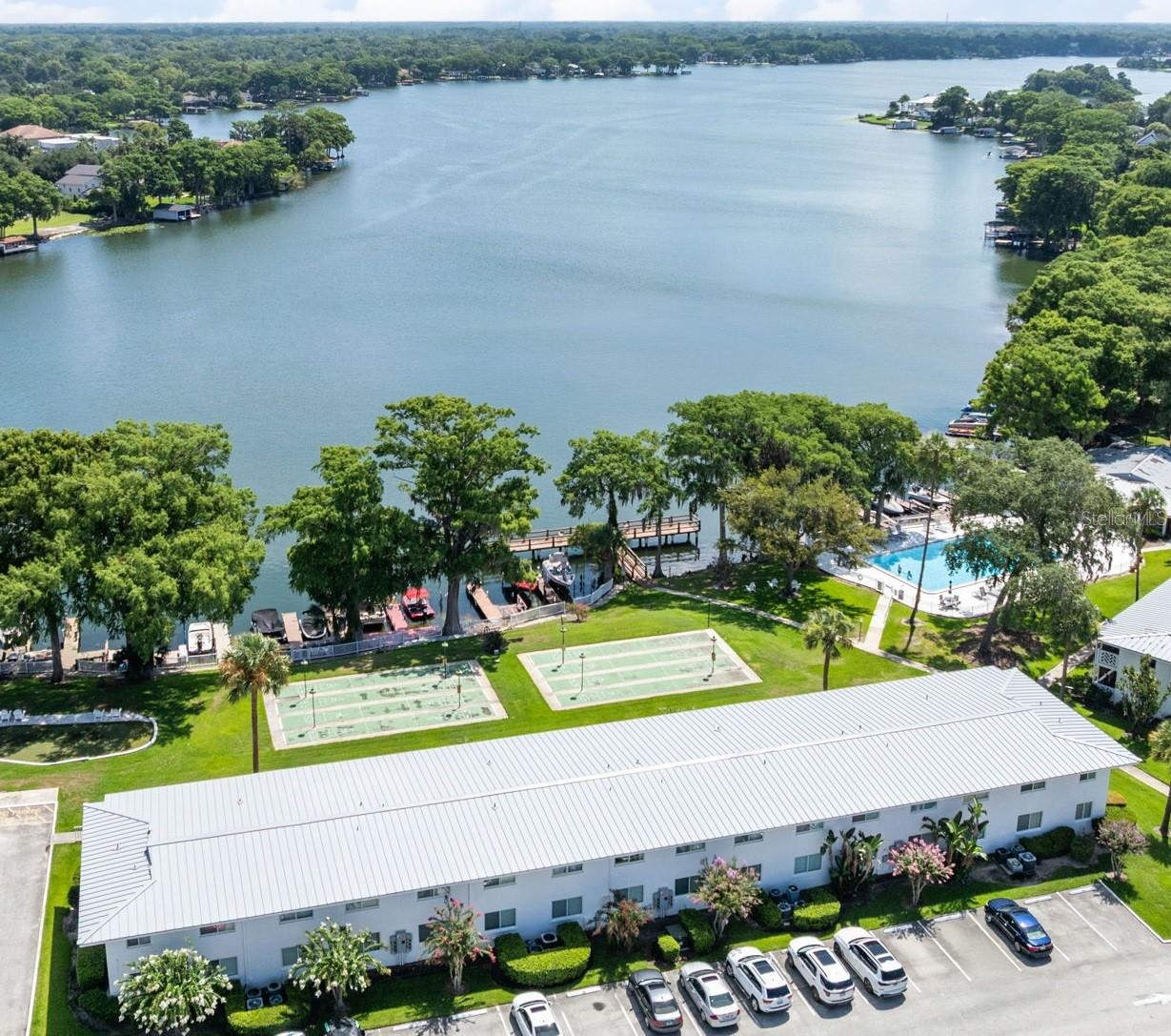 Virtually Staged. RARE LAKEFRONT opportunity to Live right on LAKE MAITLAND! Sip your morning coffee with one of the most premier views in the entire community!   BONUS: It's on the main FIRST floor, so NO STAIRS! Just a pure unencumbered view of Lake Maitland right from your living room! And only a few steps to the dock or community pool!! This unit has the EXTRA HALF BATHROOM and has been tastefully updated to accentuate it's incredible mid century modern original features, that are in immaculate condition! There may never be another unit quite like this one! The high end plantation shutters offer privacy when needed, but can stay wide open for that view!  Enjoy the remodeled Community POOL & Clubhouse all on the stunning water front of Lake Maitland which is also connected to the Winter Park Chain of Lakes. Plenty of fishing, fun and relaxing to be had on the community dock, shuffleboard and putting green! So many amenities nestled amongst the towering shade trees and mature landscaping. The Mid Century Modern architecture is about as timeless of a look that you can find that fits the Maitland/Winter Park lifestyle. You couldn't ask for a better location at just minutes from downtown Winter Park, Park Ave, SunRail station and all the restaurants surrounding the 17/92 Maitland/Winter Park Corridor. All Units recently had metal roof replacement in 2025 and were just freshly painted as well. It's completely move in ready with all New Luxury Vinyl Plank Flooring, Kitchen and bathroom updates,. This unit has not been available for many years, so don't miss out on this view!