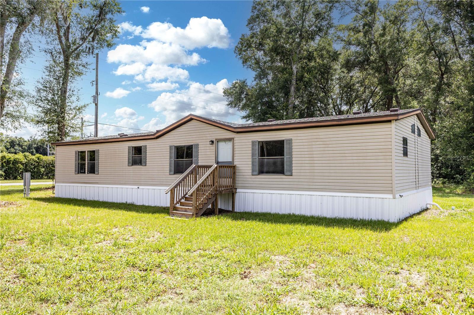Beautifully Updated Home on 1 Acre in Oxford! Experience the perfect blend of country living and modern convenience in this 1,848-square-foot, 2001 manufactured home, thoughtfully updated and move-in ready. Situated on a full acre, this property offers plenty of room to enjoy the outdoors while remaining just minutes from The Villages, shopping, dining, medical facilities, and I-75.  Step inside to discover a spacious, open floor plan featuring fresh interior paint and a bright, welcoming atmosphere. The kitchen is equipped with brand-new stainless steel appliances, making meal preparation a breeze.  The homes layout provides privacy for the primary suite while offering comfortable accommodations for family and guests. Enjoy peace of mind with the home's extensive recent upgrades, including a new roof, new HVAC system, new septic system, and new skirting—allowing you to move in with confidence and minimal maintenance concerns.  Outside, the expansive one-acre lot provides endless possibilities for gardening, outdoor entertaining, pets, or simply relaxing in a peaceful setting. Whether you're looking for a full-time residence or a quiet retreat close to all the conveniences of Central Florida, this property is a must-see!  Don't miss this opportunity to own a beautifully updated home with room to roam in the heart of Oxford!