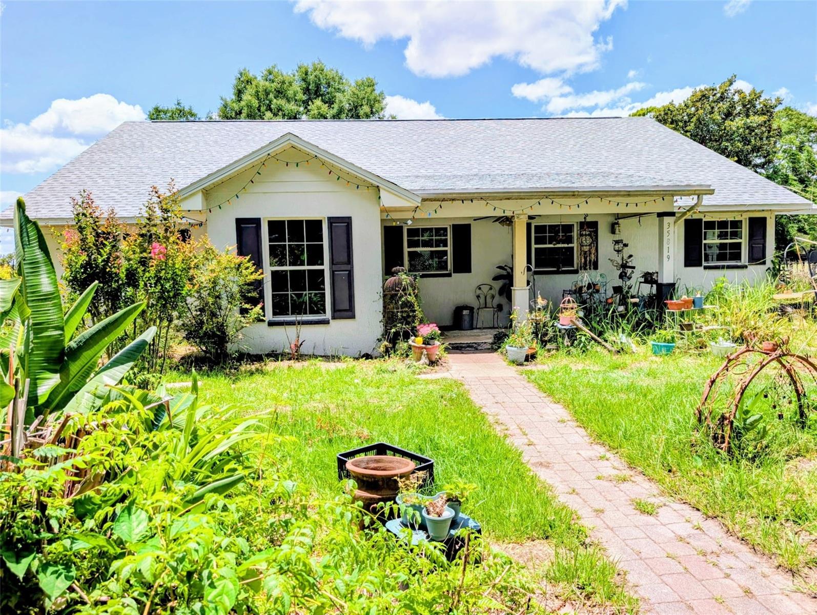 One or more photo(s) has been virtually staged. Excellent craftsmanship on this  3-bedroom, 2-bath home on 5 fully fenced and cross-fenced acres in a prime location—where comfort meets country charm. This solid concrete block home features a bright, open great room with tile flooring that seamlessly connects the kitchen, dining, and living areas—perfect for gathering and entertaining.
Enjoy peace of mind with a brand-new Roof and new HVAC system already in place. The spacious primary suite offers a double vanity and a large walk-in-tiled shower, while the secondary bath invites relaxation with a deep soaking tub.
Designed with a split floor plan, this home provides both privacy and plenty of natural light throughout. Step outside and take in the full experience: a barn and animal enclosures, multiple outbuildings for storage or hobbies, and a charming gazebo ideal for morning coffee or evening unwinding.
This property is a true homesteader’s dream, featuring an impressive variety of fruit trees—peach, plum, nectarine, pear, fig, lemon, pomegranate, and mulberry—all thriving on the land. With two operational wells and room to roam, this is your private sanctuary offering serenity, self-sufficiency, and space to grow.
Experience country living at its finest—bring your animals, your all-wheel drive vehicles, and your sense of adventure!