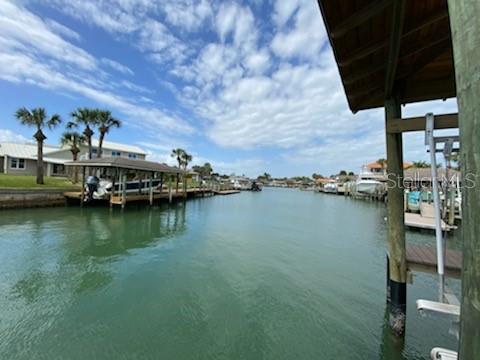 Beachside Direct Intracoastal access.  4 Bdr, 4 1/2 bath, 2 car sideload garage.  Yr built 2019 pool home with docks, 10,000 lb lift in covered boathouse in one of New Smyrna Beach's most coveted communities, Venezia.  The exterior of this home boasts coastal allure and integrity with hariboard siding over concrete block with standing seam metal roof.  A Hardy Generac whole house generator is just off to the side of the garage.  Aluminum acqua shutters adorn windows.  On the waterside is a 58' x 15' covered back patio with summer kitchen, accessed by many french doors to the pool, floating dock and boat house.  There are panoramic views north and south on this deep water intracoastal access waterway.  Inside is a designers showcase from the wood floors, shiplap and decorator tiles to the kitchen island surrounded by SubZero and Wolf stainless appliances, to plantation shutter covered windows and builtins.  The spacious master bath has his/her vanities, a soaking tub, and enclosed toilet. All bathrooms feature rain shower heads.  NOTE: Chandeliers & Sconces in Dining Room are EXCLUDED. ;Water: City
