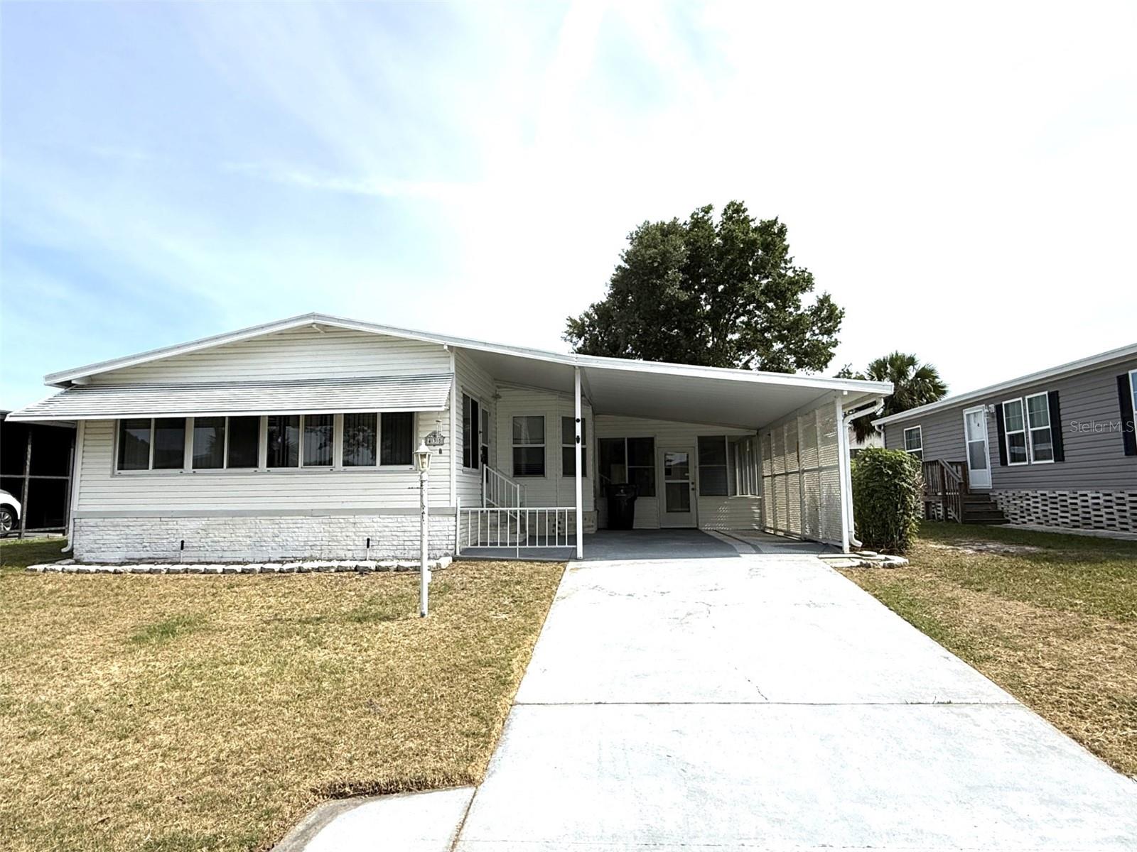 ENJOY FLORIDA LIVING AS IT'S FINEST...Welcome yourself home to this 2 Bedroom/ 2 Bath home offering over 1,300 sq ft of comfortable living space and with valuable upgrades, including True Hardwood Floors in the Living Room, Hall and Bedrooms, NEW ROOF 2026 and Newer A/C 2020. Relax and unwind in the large Florida room in the front or the screened-in lanai on the side of the house, ideal for enjoying Florida’s beautiful weather year-round. The property also features a storage shed giving you plenty of room for tools, hobbies, or seasonal items and an inside laundry with washer and dryer included. Additional storage shed behind the lanai for all your lawn equipment. Fully fenced back yard. Located in the desirable Village Park community for those 55+ years young, residents enjoy an incredibly low HOA fee of just $55 a month, which includes access to a sparkling pool and community amenities. Best of all—you own the land! Limited trailer/RV storage is also available on a first-come basis. Perfectly situated between Tampa and Orlando, this home offers convenient access to world-renowned attractions like LEGOLAND Florida Resort, Walt Disney World, Universal Studios Florida, Busch Gardens Tampa Bay, ZooTampa at Lowry Park, and Seminole Hard Rock Hotel & Casino Tampa. You’re also just minutes from shopping, dining, grocery stores, hospitals, golf courses, nature parks, and Florida’s beautiful beaches. With both Tampa and Orlando international airports within about an hour’s drive, travel is incredibly convenient. Whether you're looking for a full-time residence or a seasonal retreat, this home checks all the boxes. Don’t miss your opportunity to live in Village Park—schedule your private showing today!