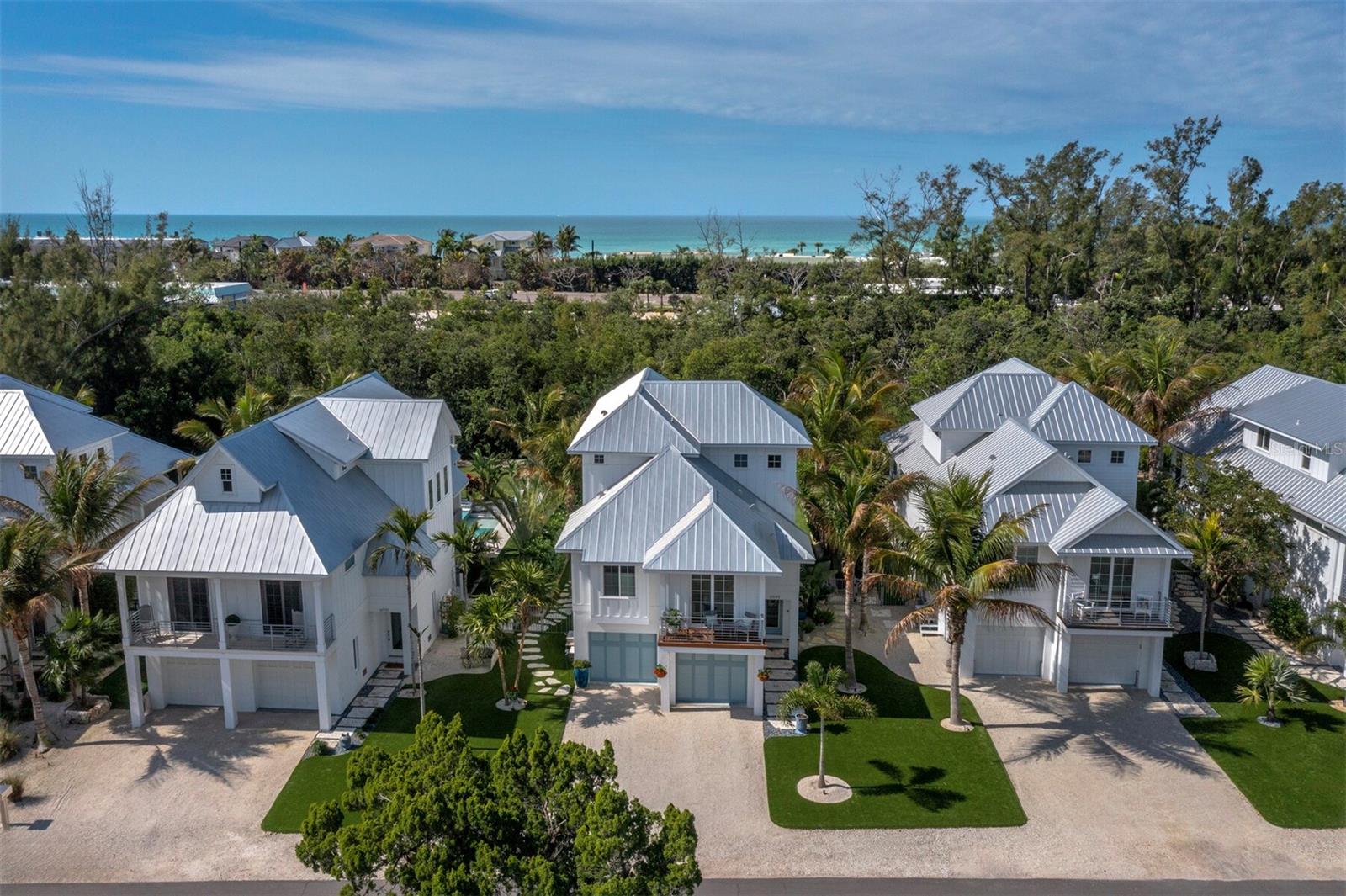 Welcome to this luxurious coastal retreat nestled in the idyllic community of Longbeach Village on the north end of Longboat Key. Offering a refined blend of elegance, comfort, and island charm, this exceptional property provides a serene lifestyle just moments from Gulf beaches and Sarasota Bay.  
Large sliders grace the open concept living area, inviting abundant natural light and providing seamless access to a generous deck, perfect for entertaining. The kitchen is a culinary enthusiast's dream with a large center island, pristine white-maple shaker cabinetry, and Cambria Torquay surfaces. Enjoy the convenience of natural gas cooking and top-of-the-line Wolf and Sub-Zero appliances.
The primary suite is on the main living level, with a private balcony and spa-inspired ensuite featuring elegant finishes.  On the private upper floor, two ensuite bedrooms provide comfort and flexibility for guests and family. A well-placed elevator provides convenient access to all levels.
Outdoor living is equally impressive with a heated saltwater pool, spa, and lush tropical landscaping that creates a private, fully fenced oasis overlooking a protected preserve and green space. The expansive covered patio and outdoor living areas provide the perfect setting for entertaining and relaxation.
Located in a golf cart-friendly neighborhood, this home offers easy access to a public boat ramp, kayak launch, fishing piers, and nearby waterfront dining and shops. Enjoy close proximity to local favorites such as Mar Vista Dockside and Shore Restaurant, as well as shopping and attractions at Whitney Plaza, St. Armands Circle, Anna Maria Island, and Sarasota.
This exceptional residence offers the ultimate island lifestyle with convenient access to boating, kayaking, paddleboarding, and pristine white sand beaches. A rare opportunity to own a private coastal oasis in one of Longboat Key’s most desirable communities.