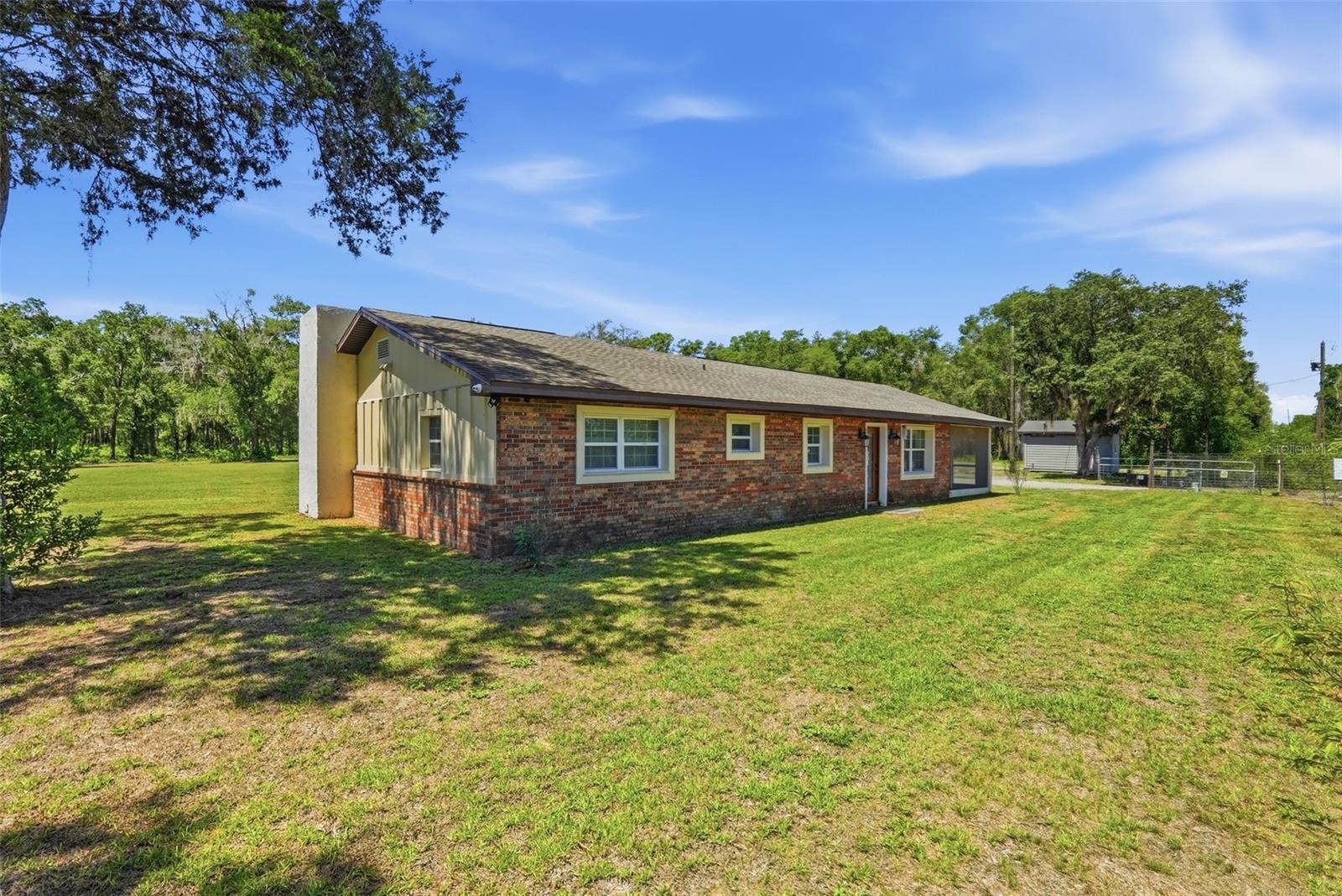 Welcome to your private country retreat on 1.92 acres! Tucked away at the end of a heavily wooded dirt road, this move-in ready smart home offers exceptional privacy. This beautifully maintained, extensively renovated 3-bedroom, 2-bath home features over 2,000 square feet of living space with a unique sunken living room and an open floor plan designed for comfortable everyday living. NO HOA and NO CDD fees! Recent renovations and improvements include the roof, electrical, septic system, well tank, water heater, and HVAC. A whole-house water softener was installed approximately six months ago. Enjoy the convenience of an integrated smart home system with built-in speakers throughout the home and screened lanai, allowing you to control lighting, audio, televisions, and security cameras from your smartphone or the central control panel. TVs and smart home equipment are included! Crown molding, tray ceilings, quartz countertops, beautifully tiled showers, and marble tile flooring throughout add timeless style and quality to the home's interior. Zoned Agricultural-Residential (A-R), this property is ideal for those seeking space, privacy, and a rural lifestyle. Bring your horses, chickens, and other livestock for personal use, create your own garden, or enjoy a hobby farm. The AR zoning offers added flexibility, including the potential for an Accessory Dwelling Unit (ADU), subject to county approval and applicable regulations. A storage shed is included, and the usable acreage offers endless possibilities for recreation, pets, gardening, and future expansion, all just minutes from shopping, dining, schools, medical facilities, the Suncoast Parkway, Weeki Wachee Springs, Gulf Coast beaches, and an easy commute to Tampa.