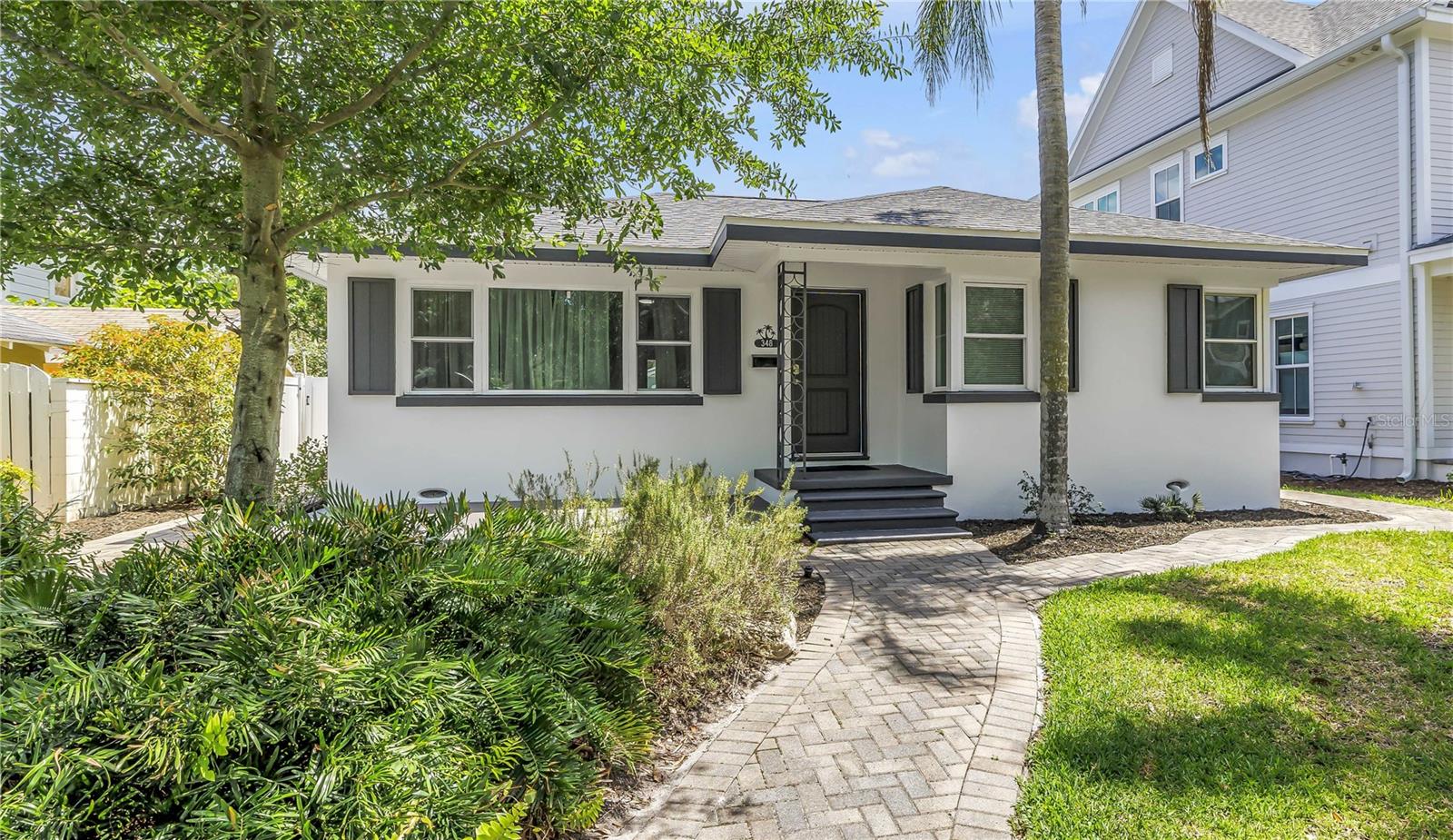 Live in the heart of Old Northeast in this beautifully maintained 2-bedroom, 2-bathroom home offering charm, comfort, and an unbeatable location. Situated in a non-flood zone, this solid concrete block, single-story home combines peace of mind with classic St. Pete living just blocks from downtown. Each spacious bedroom features its own en-suite bathroom, providing privacy and convenience. The home also offers a large living room, an updated kitchen with stainless steel and gas appliances, great storage, and a bright sunroom filled with natural light. Step outside to enjoy a lush, fenced backyard oasis with tropical and native landscaping, creating a private and serene setting for relaxing or entertaining. The outdoor pergola shades an expansive dining area perfect for year-round gatherings and covered lanai is the ideal outdoor living room. A detached, versatile flex space, complete with washer and dryer and mini-split air conditioner, can easily serve as a home office, studio, or bonus room. Additional features include a one-car garage with abundant storage and attic access, newer roof in 2024, newly refinished oak hardwood floors, and new paint inside and out. Ideally located just two blocks from North Shore Park and Tampa Bay, and only six blocks to vibrant downtown St. Petersburg. Enjoy easy access to waterfront parks, restaurants, shops, cafes, and all that downtown living has to offer.