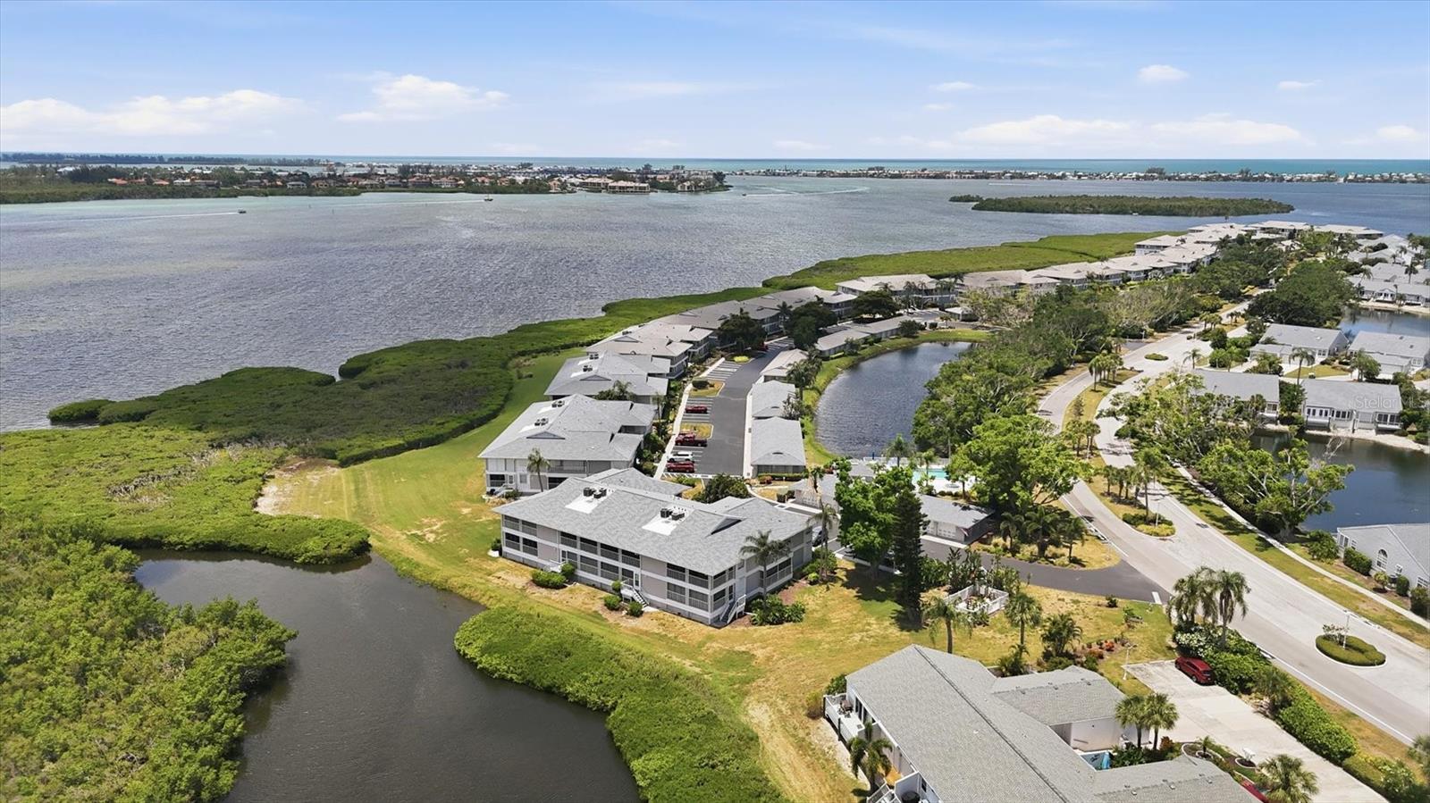 High Ceilings, Panoramic Views and Spacious Living!  This is the largest floor plan available in the gorgeous, gated community of Perico Bay Club, with 3 bedrooms and 2 baths!  You are welcomed in to the spacious foyer that is open to your large living area and has beautiful barn doors to your office space with built in shelving.  Located next to the second bedroom, this wing of the property has a full bathroom with shower and tub.  From here you step into the open floor plan with high ceilings and two porches!  Your dining room flows into your spacious family room, connected by a wall of sliding glass doors to your grand back porch where you will love the expansive views of the water and preserve.   Your bedroom shares these private views, and enjoys an updated en suite bath and large walk in closet.  This roomy unit in this picture-perfect community embraces the Florida lifestyle!  You will love your private perch, that is just a hop, skip and jump to the neighborhood pool and spa across the way.  You will also relish your garage with private storage, and all of the community amenities, just 3 miles to the sugar sand beaches of Anna Maria Island!
