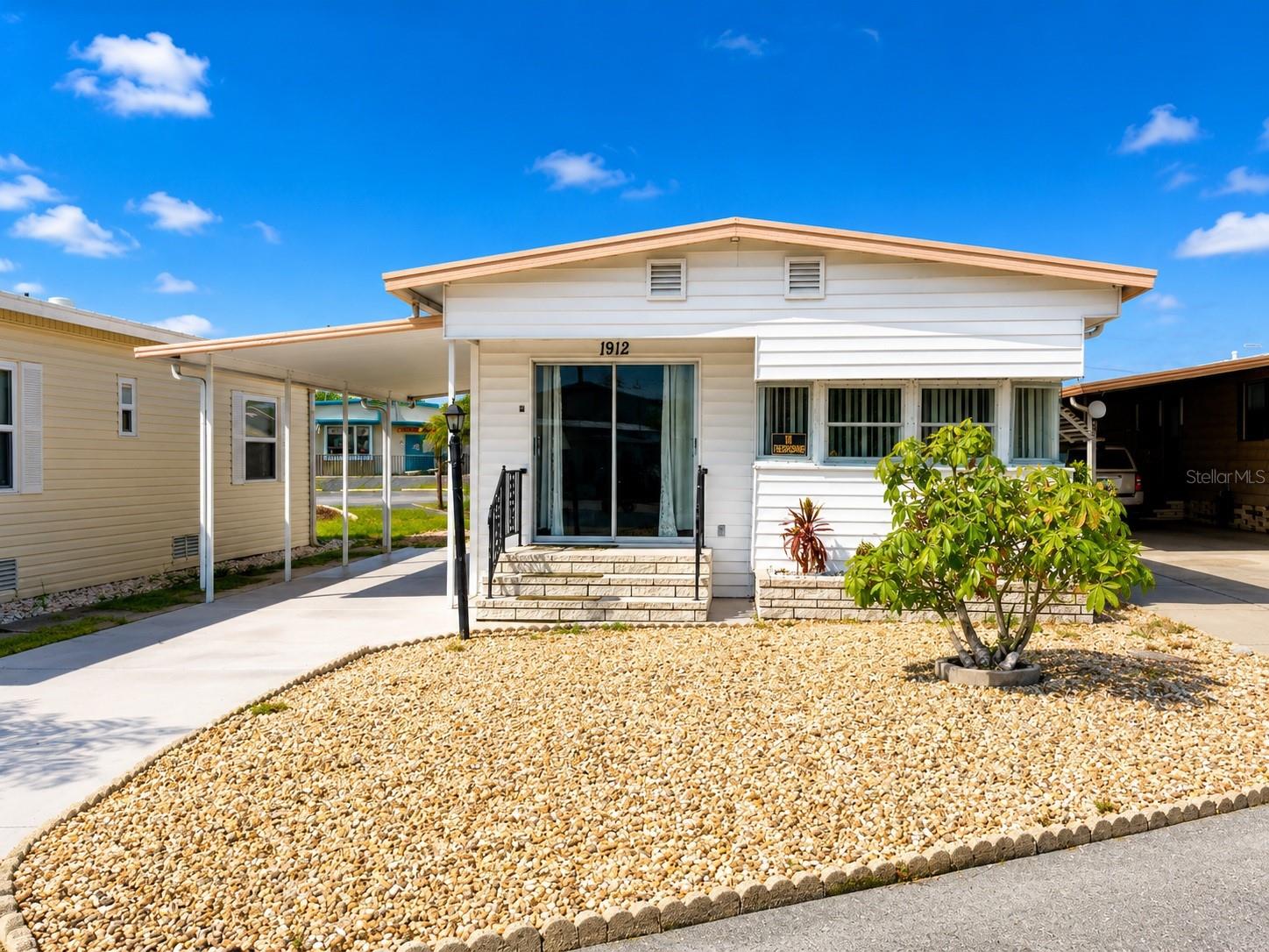 Location, location, location! This charming 2-bedroom, 1.5-bath home is ideally situated just steps from Trailer Estates' heated pool, hot tub, fitness center, woodshop, meeting rooms, and many of the community's most popular amenities. Simply walk out your back door and enjoy the active Florida lifestyle this sought-after waterfront community is known for.

Inside, you'll find an inviting open floor plan featuring attractive coastal décor and updated flooring throughout. The spacious living area flows seamlessly into the dining area and kitchen, where a breakfast bar provides additional seating for casual meals or entertaining. A newly added half bath offers added convenience for guests, while the 2017 air conditioning system provides additional peace of mind. Both bedrooms are generously sized and comfortably accommodate king-size furniture.

Storage is another standout feature. A wall of built-in hallway cabinetry provides exceptional interior storage, while outside you'll find a 10' x 7' laundry/workshop addition plus a separate 7' x 7' storage shed, offering plenty of room for tools, beach gear, hobbies, and seasonal items.

Relax on the covered front porch, enjoy the attached carport, and appreciate a home that's as functional as it is charming. Whether you're looking for a full-time residence or the perfect seasonal retreat, this property combines an open, welcoming floor plan with one of the best walkable locations in the park.

Seller is providing a $1,500 credit at full price to assist with a future leveling adjustment or as a closing cost/price reduction credit.

Located in Trailer Estates, a Special Park and Recreation District governed under Chapter 418, Florida Statutes, residents own their land, with no lot rent, CDD, or HOA fees. The annual park tax covers cable, high-speed internet, trash pickup, and access to outstanding amenities including a marina with rentable boat slips, private beach, pool, hot tub, fitness center, shuffleboard, bocce ball, pickleball, woodshop, and nearly 60 active clubs and social events. Experience one of Sarasota Bay's most vibrant and welcoming 55+ communities.