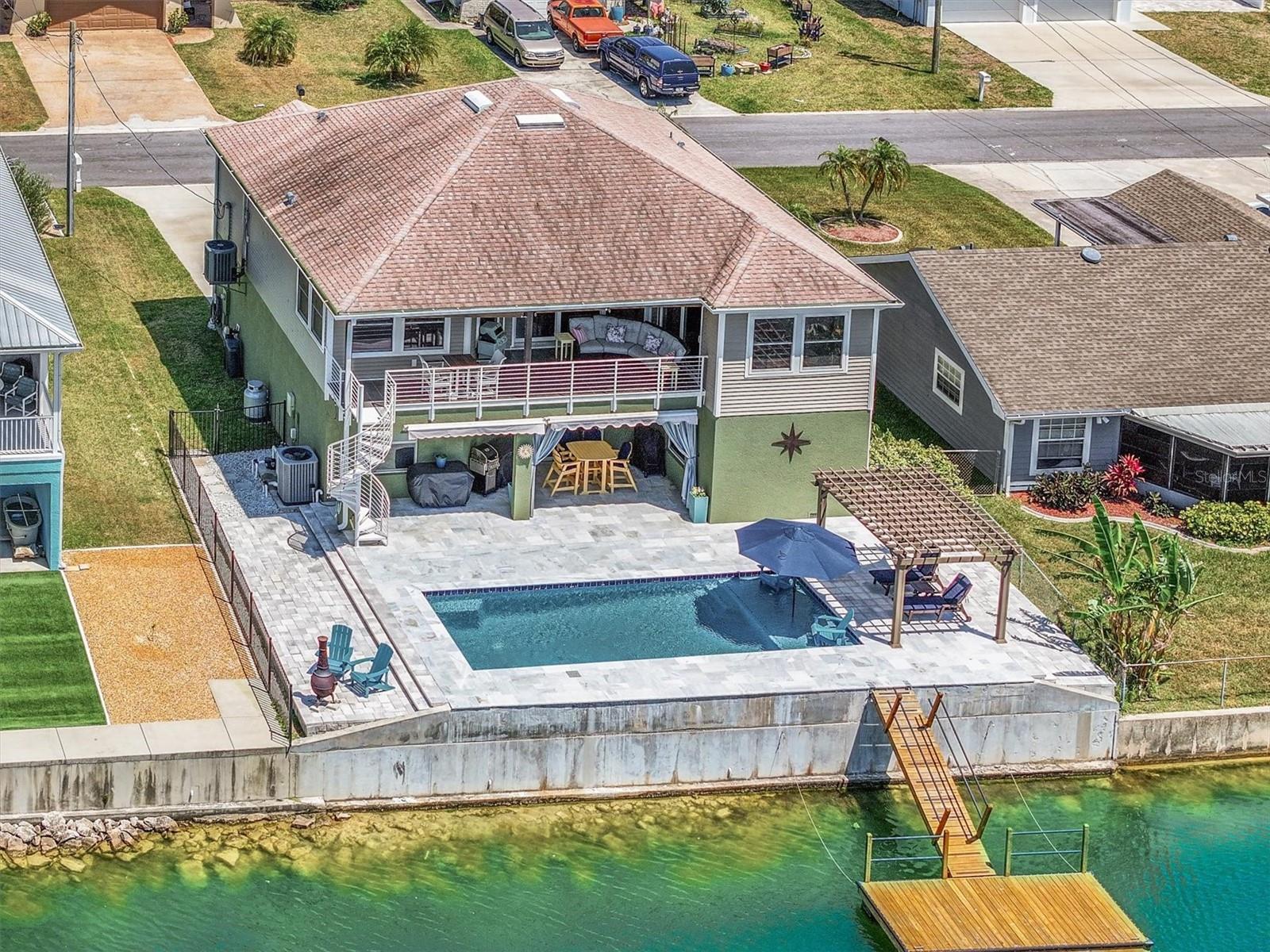Welcome to your elevated slice of coastal paradise in Hernando Beach—a beautifully updated stilt pool home designed for effortless waterfront living and laid-back Gulf Coast vibes.

This 3-bedroom, 2-bathroom home, built in 2020, delivers peace of mind with newer construction, modern building standards, and hurricane-resilient features that today’s buyers demand. Step inside to an open-concept floor plan filled with natural light, clean lines, and upscale finishes throughout—perfect for both relaxing and entertaining.

The outdoor space is where this home truly shines. The expansive backyard is centered around a stunning 12x30 swimming pool complete with a sunshelf and elegant travertine decking—your own private resort. Just beyond, enjoy 62 feet of concrete seawall and an 8x16 floating dock on a spring-fed freshwater canal. Whether you're launching a kayak, paddleboard, or small boat, or simply casting a line from your dock, this is Florida waterfront living at its finest. (Indirect Gulf access via lift and fixed bridge.)

Inside and out, the home is loaded with thoughtful upgrades:

Whole-house impact and thermal windows with Cat 5 hurricane screens on the upstairs lanai
Granite kitchen countertops, composite sink, and Moen fixtures
Stacked stone kitchen island with LED lighting
Limestone backsplash with under-cabinet lighting
Quartz bathroom vanities with premium fixtures
Updated master shower tile
Trex composite front deck and stairs

Located in the desirable middle section of Hernando Beach, there’s no HOA—giving you the flexibility for short-term rentals and the freedom to store your boat, RV, trailer, or work vehicles right at home. Ideal for those who love kayaking, paddleboarding, and smaller watercraft, or anyone seeking affordable waterfront living without compromise.

Life in Hernando Beach is unlike anywhere else. Tucked along the Gulf Coast and accessible by a quiet coastal road, this hidden gem is all about boating, fishing, and a relaxed Old Florida lifestyle. Cruise the scenic canal system out toward the Gulf, explore nearby hotspots like the Weeki Wachee River with its crystal-clear 74° spring waters, or head south to the iconic Anclote Key Preserve State Park for pristine beaches and island adventures.

From inshore fishing for redfish and snook to offshore runs for grouper and snapper, this area is a dream for anglers and boaters alike. And when you're back on land, enjoy local marinas, waterfront dining, tiki bars, and seafood markets that give Hernando Beach its unmistakable coastal charm.

Despite its secluded feel, you’re just minutes from everyday conveniences—shopping, dining, hospitals, and major routes—plus about an hour to Tampa International Airport.

If you’ve been searching for a home that captures the essence of coastal living—where every day feels like a getaway—this is it.