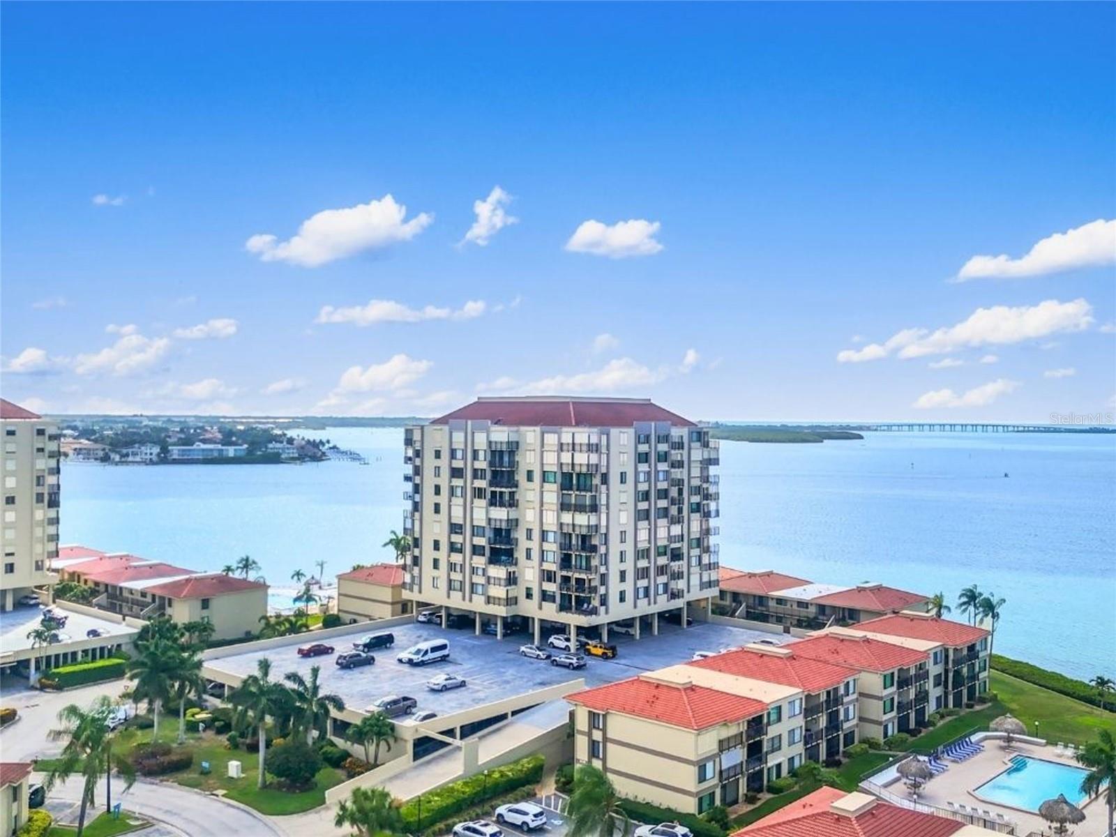 Palma Del Mar Spacious 2-Bedroom, 2 Bath, Fully Furnished, Partial Water View RENTAL Available from June 1st 2026. This 4th floor condo offers a desirable split-bedroom floor plan with peaceful water views from the private balcony. Bright, clean, and well maintained, the condo features tile flooring throughout for easy care, a beautifully updated white kitchen with quartz countertops, stainless steel appliances, and a full-size side-by-side washer and dryer. An assigned covered parking space beneath the building adds convenience, while the private storage unit on the same floor provides the perfect place for beach chairs, bicycles, golf clubs, and other coastal lifestyle essentials.
Located in the Palma Del Mar community on Isla Del Sol, this condo partially overlooks the water, golf course, and tropical landscaping. Residents enjoy a waterfront pool, scenic walking paths, club house, near walking & bike trails, and a relaxed island setting just minutes from St. Pete Beach. Whether you’re spending the day at the beach, enjoying a round of golf, dining nearby, or exploring downtown St. Petersburg just 15 minutes away, this location offers easy access to the best of the Florida waterfront lifestyle.