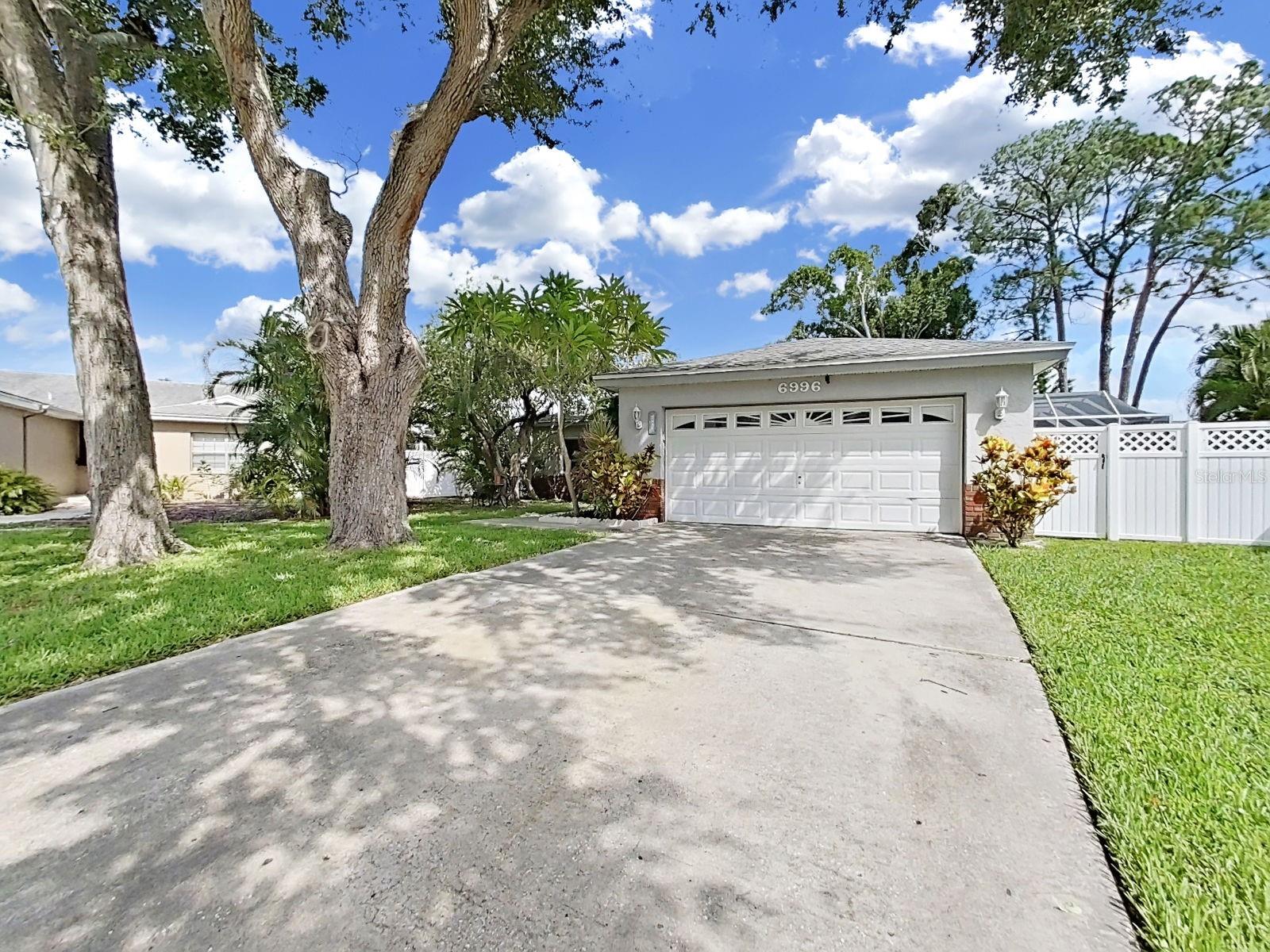 Beautifully updated 3-bedroom, 2-bath home tucked away on a quiet cul-de-sac in the desirable Pinebrook community! Situated on an oversized waterfront homesite that offers exceptional privacy and spacious side yards perfect for a playhouse, pets, or outdoor activities. Enjoy peaceful water views from all three bedrooms, a sparkling swimming pool, and an expansive approximately 1,000 sq. ft. screened lanai—ideal for entertaining or relaxing outdoors. The flexible floor plan includes a formal dining room that can easily be converted into a fourth bedroom, home office, or flex space. Recent updates include completely renovated bathrooms (2024), impact windows (2024), and new lanai screening (2025). The oversized 2-car garage, extended driveway for four vehicles, and additional cul-de-sac parking provide plenty of room for family and guests. Conveniently located near Bryan Dairy, Ulmerton, and Belcher Roads with easy access to shopping, dining, and top-rated schools. Pinebrook residents enjoy a community park with a playground, pickleball and basketball courts, picnic pavilion, and barbecue area. **Flood zone "X" with No flood insurance required by the lender.**