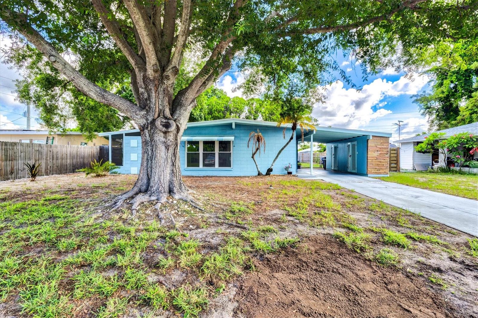 2504 N Radcliffe Place is the quintessential “Bird of Paradise” model in Bayshore Gardens Park and Recreation District nestled along Sarasota Bay. The special community district was incorporated in 1956 and is one of the earliest planned communities in Manatee County. This fabulous mid-century home was among the first 400 homes built, completed in 1957, and is just a couple blocks from the Rec Hall, Marina, Pool and Park. With a minimalistic design, this three bedroom, two bath home has been lovingly maintained and updated by the current owner. Rich terrazzo floors shine throughout the entire home. The kitchen cabinets have been modernized, yet the original pulls and built-in oven remain, staying true to the home’s original character. Each of the three bedrooms offer natural lighting and ample closet space. The tile in the hall bath remains original, while the primary bath has been modernized for today’s living with a luxurious step-in shower. One of the most important features are the high quality impact windows and doors installed in 2018 - this provides significant peace of mind as well as dramatic reduction in homeowner’s insurance costs. An inviting screened lanai can be accessed from the living room or kitchen, welcoming visitors outdoors while providing protection from the elements. The generously sized lot is fully fenced in the back with newer wooden privacy fencing, while the front features a magnificent Oak tree and open space. There are endless possibilities to transform the yard into a special oasis. An oversized carport and additional storage are also part of the original design. The roof was replaced in 2015, the a/c in 2025.