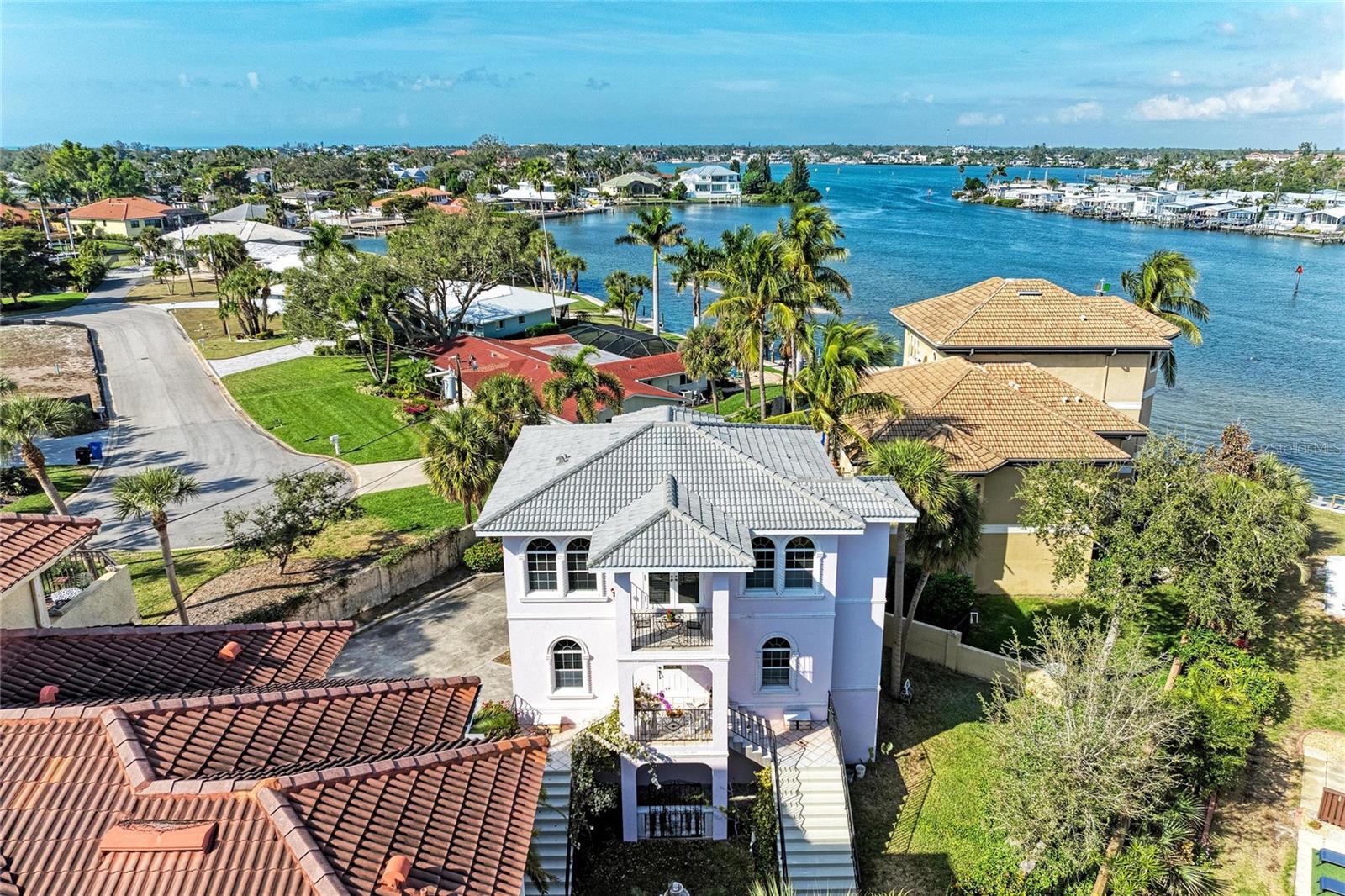 On Venice Island, this private waterfront retreat with its own boat dock and no-bridge Gulf access offers the rare opportunity to live the ultimate coastal lifestyle just steps from Historic Downtown. Imagine yourself waking up to shimmering bay views, stepping onto your private balcony with coffee in hand, and being on the open Gulf in minutes — no bridges, no hassle, just pure waterfront living on Venice Island. This is not just a home… it’s a lifestyle few ever get to experience, tucked inside a private gated enclave of only four residences, just two blocks from Historic Downtown Venice.
Set within a charming waterfront community on Venice Island, this Mediterranean-inspired home offers breathtaking bay views from both living levels, a private boat dock, and seamless no-bridge Gulf boating. Whether you’re cruising at sunrise, walking to dinner downtown, or enjoying the coastal breeze from one of four outdoor living spaces, every day here feels like a vacation.
Inside, the main living level features an open great room layout with soaring ceilings, crown molding, and walls of windows capturing west and north-facing bay views from nearly every room. The kitchen, dining, and living areas flow effortlessly for entertaining, while three levels of waterfront observation porticos bring the outdoors in at every turn.
 Mediterranean Architectural character defines the home — from the grand staircase entry framed by serpentine columns and doors, to the pink “Italian Lace” stucco exterior, wrought-iron rails, tranquil fountain courtyard, and historic wrought-iron gate reclaimed from the iconic King House in Newport, Rhode Island.
Additional highlights include 24/7 access to your dock and absolutely no bridges to the Gulf, allowing you to be on open water in minutes. The home offers stunning bay views from both living levels, along with three levels of waterfront observation porticos that create a seamless connection to the outdoors. There are two bay-view balconies plus two additional patios, providing multiple spaces to relax or entertain, as well as a private fenced yard for added privacy. An elevator services all levels, and the oversized 28’ x 32’ garage easily accommodates multiple vehicles, water toys, or additional storage. The property was built in 2001 and has been meticulously maintained, including a brand new tile roof in 2025 and a new A/C system in 2025. This Mediterranean-inspired residence was featured in a local Venice guide for its architecture. 
This is a rare opportunity to own a truly one-of-a-kind waterfront residence where kayaking, boating, walkability, and timeless Venice Island charm converge — just moments from dining, shops, beaches, and everything that makes island living unforgettable.