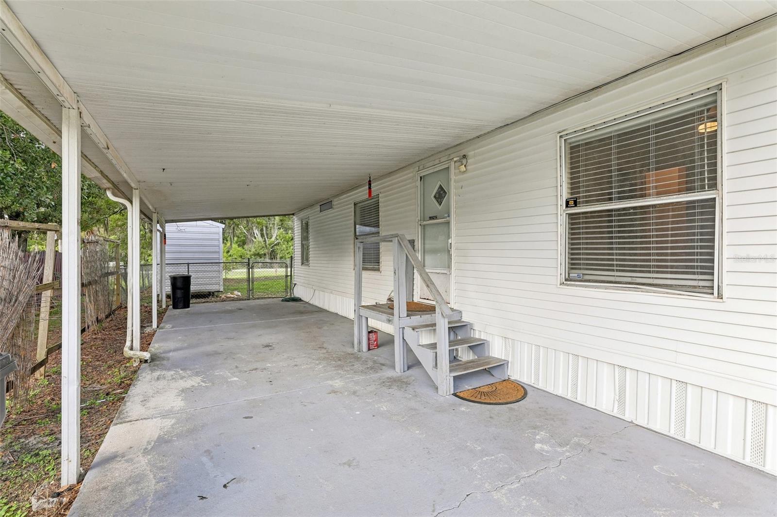 Fresh Update! Nestled on an oversized 0.25-acre lot, shaded by mature oak trees, this 3-bedroom, 2-bath manufactured home offers privacy, space, and convenience. The fenced backyard with raised flowerbeds provides ample room for entertaining, pets, gardening, or future improvements, while the bright interior features comfortable living areas and abundant natural light. Enjoy Florida living from the covered porch, with additional features including central HVAC, a utility/storage building, new skirting, and a carport. Conveniently located near shopping, dining, healthcare, and major roadways. No lot lease—own the land and enjoy the flexibility this property provides. Don’t miss out on this opportunity, call to set a tour today!