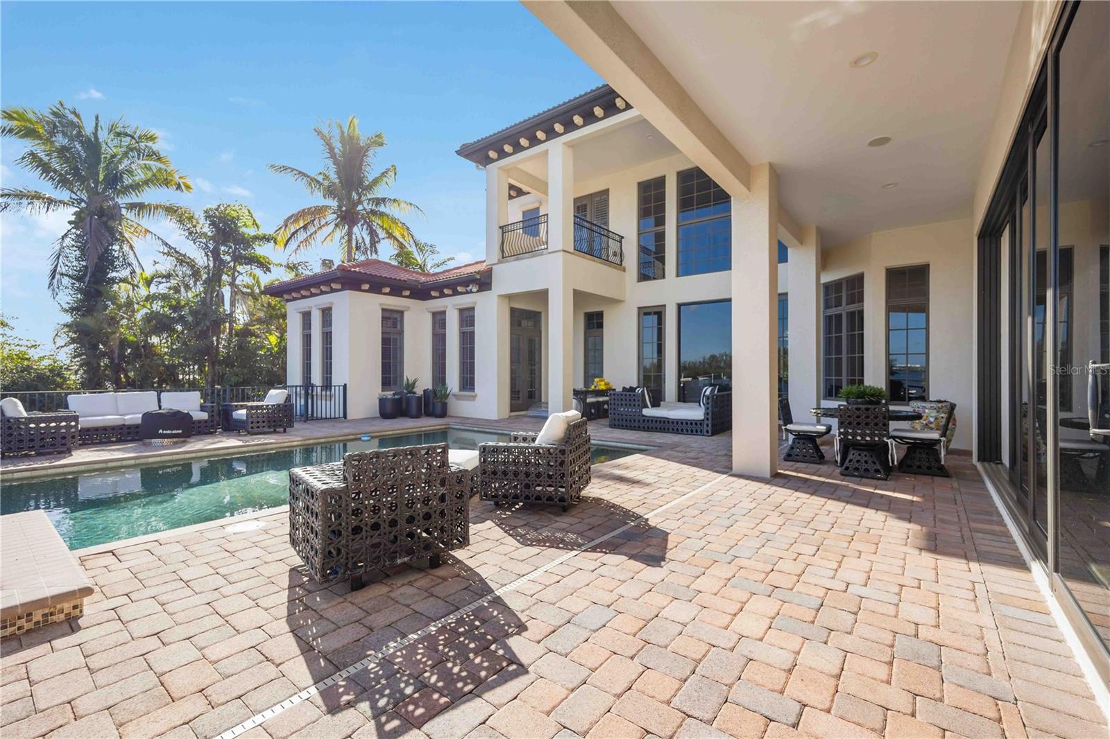 Embark on a coastal living experience at 825 Tropical Circle, an extraordinary bayfront residence designed for an unmatched waterfront lifestyle and captivating downtown views. Crafted with meticulous attention to detail in 2010, this 6,000 sq. ft. coastal sanctuary seamlessly integrates indoor and outdoor spaces on a private 20,000 sq. ft. Point Lot, boasting 122 feet of Open Bay. Immerse yourself in the allure of Sarasota Bay with cutting-edge dock featuring shore power, and a boat lift—complementing the serene surroundings. This elegant abode offers four to six bedrooms, 4 full plus 2 half-baths, and high-end finishes throughout, including a Gourmet Chef's Kitchen with Sub Zero, Fisher-Paykel, Wolf Gas Range, and Bosch appliances. The first-floor Grand Master Suite provides a haven of luxury, featuring bay views, European Oak floors, a private study area, and dual his and hers baths. Indulge in a jetted soaking tub or unwind in a garden shower with panoramic bay views. Entertaining is elevated with a three-tiered home theater, a separate formal dining room, a butler’s pantry, and a 500-bottle wine cellar. Embrace the lush outdoor spaces with both indoor and outdoor fireplaces, surrounded by mature tropical landscaping, including Tropical Palms, Mango trees, and Bougainvillea. A short stroll from the World Famous Siesta Key Beach, this exclusive retreat seamlessly blends tranquility with vibrant coastal living. Revel in the nearby Village, offering an array of dining and entertainment options. Experience the epitome of waterfront luxury—schedule a private tour and make 825 Tropical Circle your coastal haven.