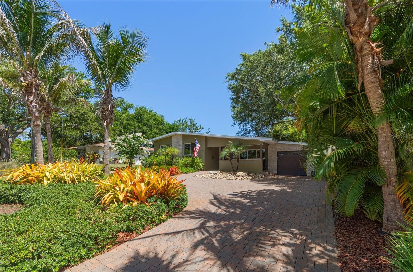 Welcome home to this beautifully updated Belleair residence, where timeless mid-century character meets today's modern lifestyle on a quiet street in one of the area's most desirable neighborhoods. Surrounded by lush tropical landscaping and exceptional curb appeal, the welcoming pavered front porch invites you to slow down and enjoy the charm of this special home. Step inside to discover an open, light-filled floor plan enhanced by gorgeous flooring and thoughtfully designed living spaces that flow effortlessly from room to room. The stunning dine-in kitchen is the heart of the home, featuring an eye-catching industrial-inspired design, a large island with seating, stainless steel appliances, and an open connection to the spacious family room. Floor-to-ceiling impact windows flood the space with natural light, creating a warm and inviting atmosphere for everyday living and entertaining alike. French doors in the kitchen open to a charming pavered patio, seamlessly blending indoor and outdoor living while providing the perfect setting for morning coffee, weekend gatherings, or evenings under the stars. The spacious primary suite is a peaceful retreat filled with natural light and complemented by a beautifully updated ensuite bath featuring a walk-in shower. The additional bedrooms are equally inviting, offering generous closet space and flexibility for family, guests, or a home office, and share an updated bath. Ideally located just moments from the Belleair Recreation Center, local boutiques, restaurants, golf, and the area's world-renowned sparkling Gulf beaches, this move-in-ready home offers the perfect combination of style, comfort, and the relaxed Florida lifestyle you've been searching for.