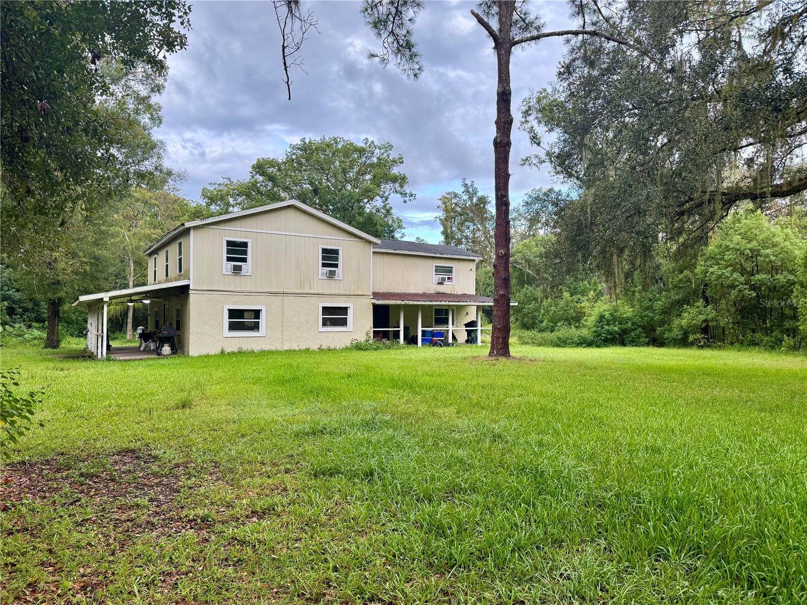 Great 2.05 Acre Property located in the center of of EVERYTHING in Wesley Chapel!!!! This log cabin home, yes you heard that right, this is a real log cabin that is a handy man special is ready to be brought back to its former glory. Complete with 4 bedrooms and 3 bathrooms, and a detached 2 car garage. The Yard is HUGE and secluded. You will feel like you are in the Country yet you are close to everything!!! Home is cash only as it does need repairs and updating. A/C needs work, Well Pump is new, Roof 2015, W/H is newer.