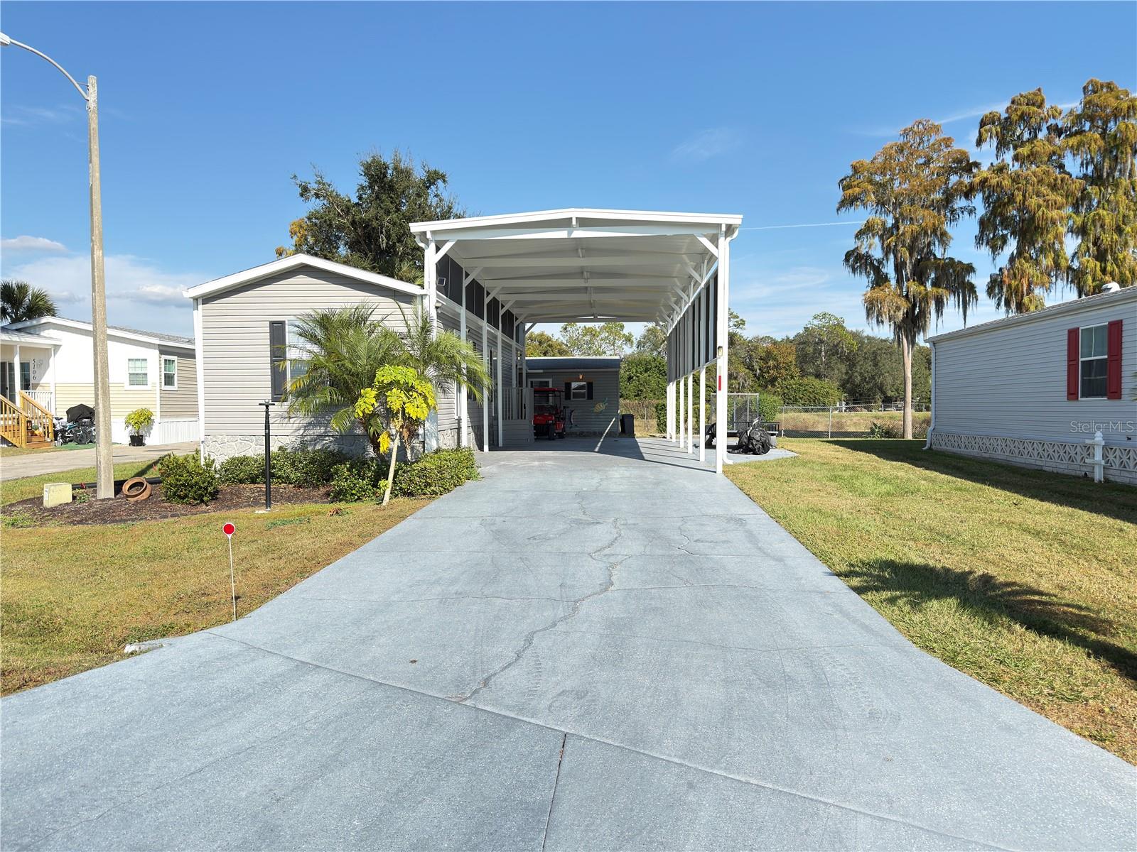 Welcome to refined Class A living in Mount Olive Shores Phase 4 — where luxury, functionality, and community come together seamlessly.

This impeccably maintained 2016 RV Port Home is thoughtfully positioned on a solid concrete slab and showcases beautiful new luxury vinyl plank flooring throughout, creating a clean, modern aesthetic. The open, inviting interior comes fully equipped with a range, refrigerator, dishwasher, ceiling fans, elegant window treatments, and a cozy fireplace that adds warmth and character to the living space.

Designed with both comfort and versatility in mind, the property also includes a separate 200-square-foot air-conditioned casita complete with a full bathroom and private living area — ideal for hosting guests, creating a home office, or providing additional privacy.

For the motorcoach enthusiast, the impressive 48’ x 17’ x 14.5’ covered RV port is complemented by a spacious concrete pad with full public utility hookups, ensuring convenience and ease of use for your Class A motorhome.

The annual HOA fee covers basic lawn care and maintenance of common areas, allowing you to enjoy a pristine environment without the upkeep. As a gated community located just 3.5 miles from I-4, Mount Olive Shores provides quick access to shopping, top-tier medical facilities, Tampa and Orlando International Airports, and Central Florida attractions — all within approximately one hour.

This deed-restricted community is specifically designed for Class A motorhome owners. Ownership or lease of a Class A motorhome is required your first year of residency, preserving the integrity and lifestyle the neighborhood is known for.

Adding even greater value, the community now features a brand-new 5,000-square-foot heated and cooled Community Center. Residents enjoy a full kitchen, regulation pool and shuffleboard tables, dart boards, arcade games, a dedicated card room, library, vending area, and a covered BBQ lanai ideal for gatherings. A vibrant social calendar includes Bingo, karaoke nights, potluck dinners, holiday celebrations, and seasonal events throughout the year — fostering connection, activity, and a true sense of belonging.

This is more than a property. It is a turnkey opportunity to step directly into the elevated RV lifestyle you’ve been seeking.