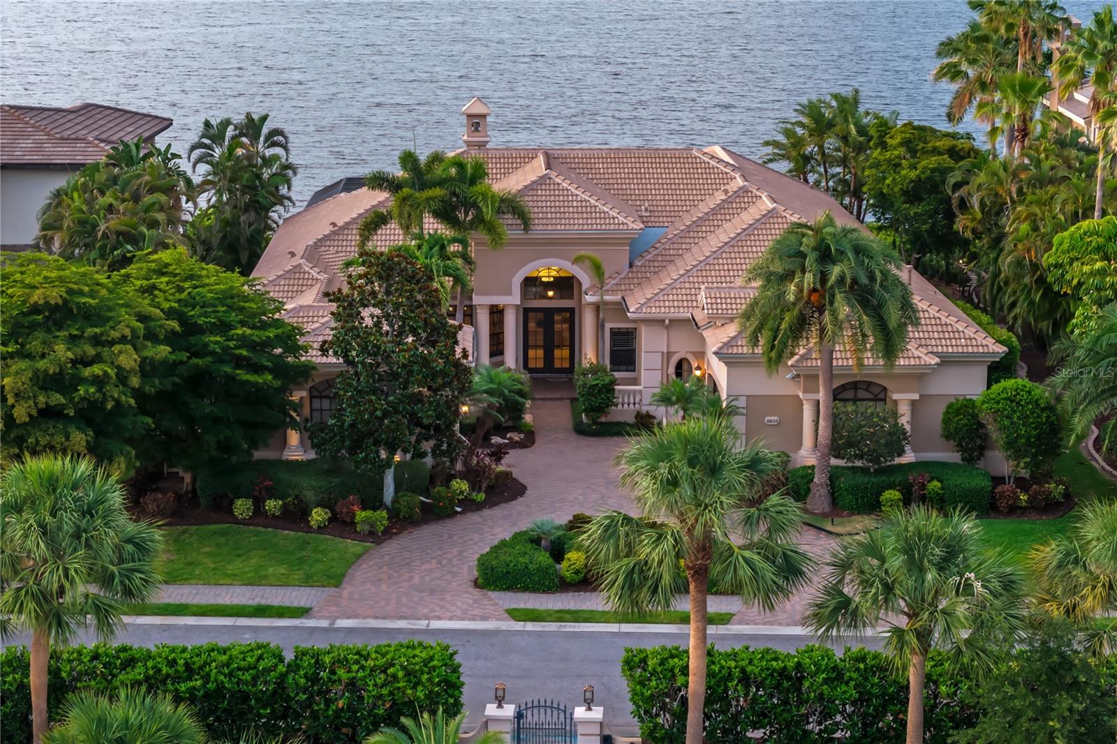 Located within the gated waterfront community of Hawk Island, 3803 Hawk Island Drive offers direct boating access, updated waterfront infrastructure, and a private canal-front setting with no fixed bridges to the Manatee River, Tampa Bay, and the Gulf of Mexico. Recent improvements include a new roof, updated boat and jet ski lifts, brand-new Monogram appliances, and a fully renovated primary bath, creating a move-in-ready waterfront property in one of Bradenton's premier boating communities.
Designed around the water, the home features expansive living spaces, high ceilings, and large windows that keep the canal views connected to everyday living. The floor plan provides the scale expected in a luxury waterfront residence while maintaining a comfortable flow between gathering areas, private spaces, and outdoor living.
The kitchen anchors the home and opens naturally to the surrounding living and dining areas, creating a layout that works equally well for entertaining and daily life. Throughout the residence, generous room sizes and flexible living spaces allow for a variety of uses, including dedicated office space, fitness areas, media rooms, or additional guest accommodations.
Outdoor living plays a central role in the property. Multiple covered lanais, open-air terraces, a pool and spa, dedicated pool bath, and private dockage create a setting built around Florida's year-round waterfront lifestyle. Updated boat and jet ski lifts provide immediate access to the water, while the protected canal location offers convenient boating access without sacrificing privacy.
The primary suite serves as a private retreat overlooking the water and is complemented by a fully renovated bath designed with clean finishes and modern functionality. Additional guest suites are thoughtfully separated throughout the home, providing comfort and privacy for family and visitors alike.
Mature tropical landscaping, substantial garage space, and an expansive driveway approach contribute to the property's sense of privacy and arrival. The setting offers the security of a gated community while remaining close to the destinations that define Gulf Coast living.
Located minutes from Anna Maria Island, downtown Sarasota, Lakewood Ranch, private clubs, championship golf, waterfront dining, and Gulf beaches, 3803 Hawk Island Drive combines deep-water boating access, meaningful recent improvements, and estate-scale waterfront living within one of the region's most established luxury boating communities.