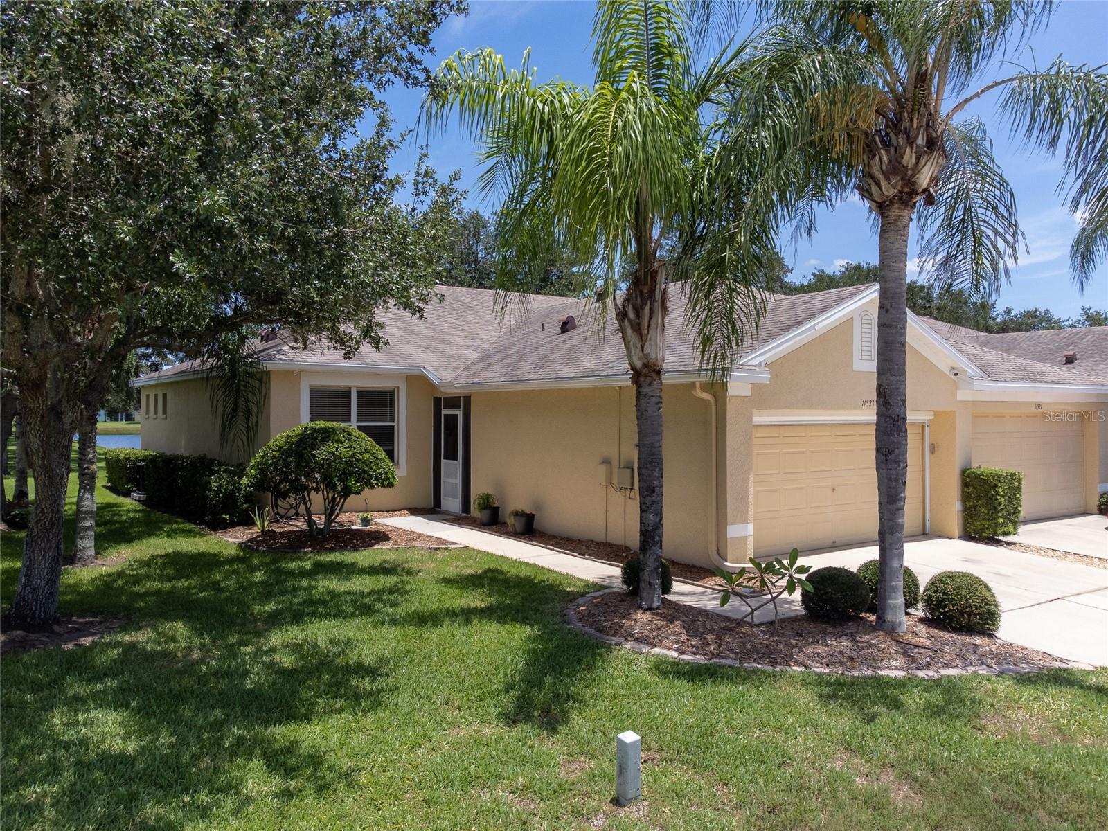 Welcome to carefree waterfront living in the highly sought-after Rivercrest community! This beautifully updated 2-bedroom, 2-bath villa with a 2-car garage offers the perfect blend of comfort, style, and low-maintenance living with peaceful pond views and no backyard neighbors.

Step inside to discover a bright, open floor plan enhanced by luxury vinyl plank flooring throughout, abundant natural light, and modern ceiling fans. The spacious living and dining areas flow effortlessly into the well-appointed kitchen, featuring white cabinetry, recessed lighting, stainless steel appliances (2020), an oversized 80/20 sink, generous counter space, and a breakfast bar perfect for casual dining and entertaining. The washer and dryer are also included for added convenience.

The private owner's suite overlooks the tranquil pond and offers a large walk-in closet along with a beautifully remodeled en-suite bathroom showcasing stylish gray and black dual vanities, a frameless glass walk-in shower, and an upgraded rain shower head. The split-bedroom layout provides privacy for guests, while the secondary bathroom features an updated white vanity and a tub/shower combination.

Enjoy Florida's beautiful weather year-round from the screened lanai overlooking the water or relax on the screened front porch with ceramic tile flooring. Additional upgrades include a whole-house water filtration system, Ring doorbell, outdoor security cameras, exterior motion lighting. 
Major updates provide peace of mind, including a new HVAC system (2026), roof (2018), hot water heater (2020), exterior paint (2019), and stainless steel kitchen appliances (2020).

The monthly HOA delivers true maintenance-free living by covering roof replacement, exterior painting, lawn care, shrub trimming, building insurance, and pressure washing of sidewalks and driveways.

Rivercrest residents enjoy resort-style amenities including multiple community pools, a splash park, clubhouse, playgrounds, tennis, basketball and pickleball courts, scenic walking trails, dog park, and year-round community events. Located just minutes from shopping, restaurants, entertainment, US-301, I-75, top-rated schools, and an easy drive to Tampa and Florida's award-winning Gulf beaches, this move-in-ready waterfront villa offers the Florida lifestyle you've been dreaming of.