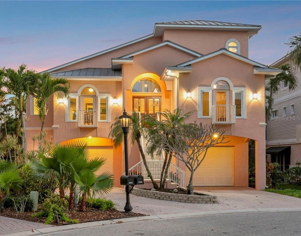 Your slice of waterfront paradise awaits in the exclusive gated boating community of Hawks Harbor in Bradenton. This rare deep-water enclave of just 54 custom-built homes is one of the area's best-kept secrets, offering direct access to Sarasota Bay and the Gulf of Mexico with no fixed bridges—an exceptional opportunity for avid boaters and waterfront enthusiasts.

Perfectly positioned on a tranquil canal, this stunning three-bedroom, three-bath residence offers 2,978 square feet of thoughtfully designed living space, complemented by an extraordinary 1,900+ square feet of garage space. With room for up to six vehicles, plus boats, golf carts, paddleboards, fishing gear, and other recreational toys, this oversized garage is a dream for collectors, hobbyists, and outdoor adventurers alike.

Built for lasting beauty and peace of mind with three levels of concrete block construction and a heavy-gauge metal roof, the home seamlessly blends timeless coastal architecture with modern functionality. A lighted pathway leads to your private dock, featuring water and electric service, a 10,000-pound boat lift with newer motors, and a custom fish-cleaning station designed for three anglers—perfect for preparing the day's catch after exploring the pristine waters of the Bay and Gulf.

Inside, soaring ceilings, expansive windows, Travertine flooring, and elegant stone surfaces create a light-filled atmosphere that celebrates the waterfront setting. The chef-designed kitchen offers exceptional workspace, storage, and flow, making it equally suited for entertaining guests or preparing intimate meals at home.

French doors throughout the residence open to multiple outdoor living areas, creating a seamless connection between indoor comfort and the natural beauty beyond. Outdoor spaces span three levels and include two covered terraces on the main living floor, a heated pool and sun deck below, and a private third-floor balcony overlooking the water.

The primary suite serves as a true retreat, offering a romantic sanctuary elevated among lush tropical landscaping. Wake each morning to serene views of swaying palms and vibrant greenery, then step onto your private balcony to enjoy breathtaking sunrises, gentle coastal breezes, and panoramic water vistas. This peaceful haven perfectly captures the essence of luxury waterfront living.

A spacious loft with a Murphy bed provides flexible accommodations for guests, a home office, or an additional lounge area. The great room features a ventless natural gas fireplace, adding warmth and ambiance to gatherings year-round.

Additional conveniences include a chair lift from the ground level to the main living area, ideal for transporting groceries, luggage, heavy items, or assisting guests. Recent updates include soffits, gutters, and air conditioning for added peace of mind.

Ideally situated between downtown Sarasota and downtown Bradenton, Hawks Harbor offers convenient access to Sarasota-Bradenton International Airport, IMG Academy, St. Armands Circle, acclaimed dining and shopping destinations, renowned arts and entertainment venues, and the world-famous beaches of Siesta Key, Lido Key, and Anna Maria Island—many of which can even be reached by boat.

Experience the very best of Southwest Florida waterfront living and discover the unmatched lifestyle that awaits at this exceptional Hawks Harbor residence.