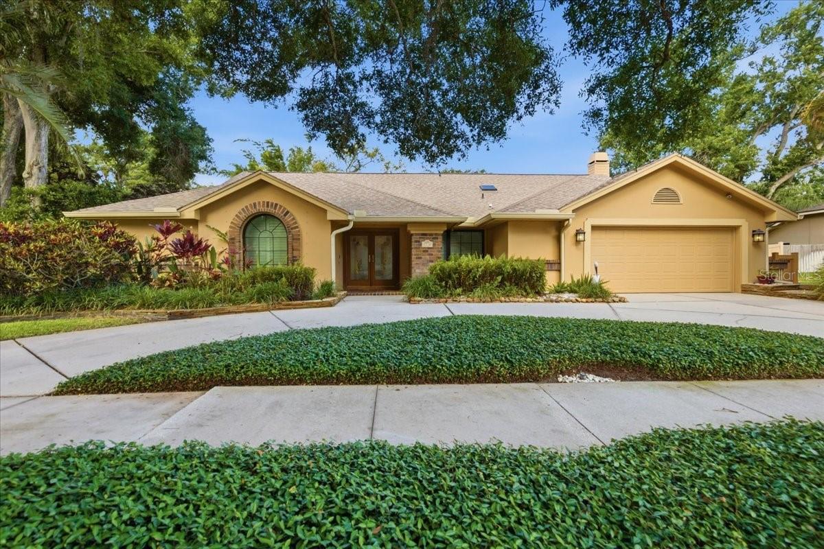 Under contract-accepting backup offers. LOCATION, LOCATION. All roads lead to the water from this spacious executive pool home in the desirable Country Woods community. Situated on an oversized 1/3+ acre homesite with majestic trees and lush professional landscaping, this meticulously maintained 5-bedroom, 3.5-bath home offers 3,224 square feet of living space with thoughtful updates throughout.

Inside, the home features an expansive open floor plan, Pella hurricane windows and doors, soaring ceilings, multiple skylights, plantation shutters, three remodeled bathrooms, and attractive 20-inch travertine-style porcelain tile flooring throughout. From the circle driveway, enter through stained-glass double doors into a light-filled living room with beautiful pool, backyard, and sunset views.

The heart of the home is the spacious kitchen with granite countertops, 42-inch wood cabinetry, stainless steel appliances, an oversized refrigerator/freezer, updated island, breakfast bar, and wine fridge. A nearby eat-in area offers casual dining and pool access. The family room offers custom built-in display shelving, a mantle, and a fully functional wood-burning fireplace. The formal dining area provides ample space for hosting family and friends.

The split layout provides function and privacy. One wing includes three generously sized bedrooms, an updated Jack-and-Jill bathroom with tub and shower, and an additional full bathroom with direct access to the lanai and pool. Both bathrooms feature new quartz vanities, sinks, and lighting. On the opposite side, the spacious primary suite offers abundant natural light, evening views, an oversized newly painted walk-in closet, and an elegant en-suite bathroom with a garden tub, separate glass shower, granite vanity, basin sinks, and dark wood cabinetry. The fifth bedroom can also be used as a home office, nursery, exercise room, sitting room, or private flex space. An updated half bath with a pocket door is also attached.

The outdoor living area is a true private retreat, featuring a heated saltwater pool and spa with cobalt blue tile and a new salt cell. The pavered lanai, wood deck, and travertine stone walkways wind through tropical landscaping, creating a peaceful setting surrounded by open green space. Five rooms with direct access to the pool, and multiple windows overlook the spa and backyard.

MAJOR UPDATES include a roof and skylight installed in 2022, six-foot architectural aluminum backyard fence in 2022, two-unit AC system in 2018, updated blower and ducts with UV protection in 2026, exterior paint in 2017, interior paint in 2018, garage door spring in 2025, pool heater and pump in 2025, refurbished irrigation system in 2021, lanai serving cabinet with quartz counter in 2018 and plumbing for a sink added in 2025, induction stove/range in 2021, Bosch dishwasher in 2021, GE Wi-Fi-connected washer and dryer, whole-house water re-pipe and water heater in 2025, rehabbed garage walls with fresh paint and resurfaced polyurethane flooring, and full-house gutters with leaf guards in the front and pool cage in 2026.

The oversized garage includes shelving, a workbench, storage alcove, and an attached concrete shed, providing excellent storage for tools, toys, and equipment. Country Woods offers a convenient location near grocery stores, restaurants, bike rentals, the Pinellas Trail, and the award-winning Gulf beaches of Honeymoon Island and Caladesi Island. View the virtual tour for additional photos of this exceptional home.