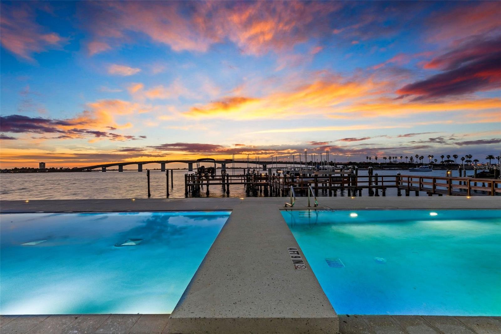 AQUA, an ultra-exclusive boutique waterfront building of just seven residences, offers one of the desirable luxury living opportunities in downtown Sarasota. Designed by renowned architect Guy Peterson, this exceptional 3,590-square-foot second-floor residence showcases unobstructed Sarasota Bay views and includes a private boat dock with 16,000-pound lift. Private elevator entry opens to expansive living spaces framed by a dramatic wall of windows and impact-rated accordion glass doors leading to a spacious waterfront terrace with natural gas for grilling. The chef’s kitchen features abundant storage, a large dual-sink island, natural gas range, and premium Wolf, Sub-Zero and Miele appliances. The luxurious primary suite offers floor-to-ceiling water views, custom closet and spa-inspired bath with soaking tub. Two additional en-suite bedrooms provide generous space and privacy. Owners enjoy gated entry, a private two-car garage, concierge-staffed lobby, and an impressive collection of amenities including fitness center, yoga room, sauna, wine storage, executive meeting space and a stunning rooftop terrace with panoramic bay, gulf and skyline views. Ideally on Golden Gate Point, just moments from downtown dining, arts, and marinas while offering a quiet residential setting.