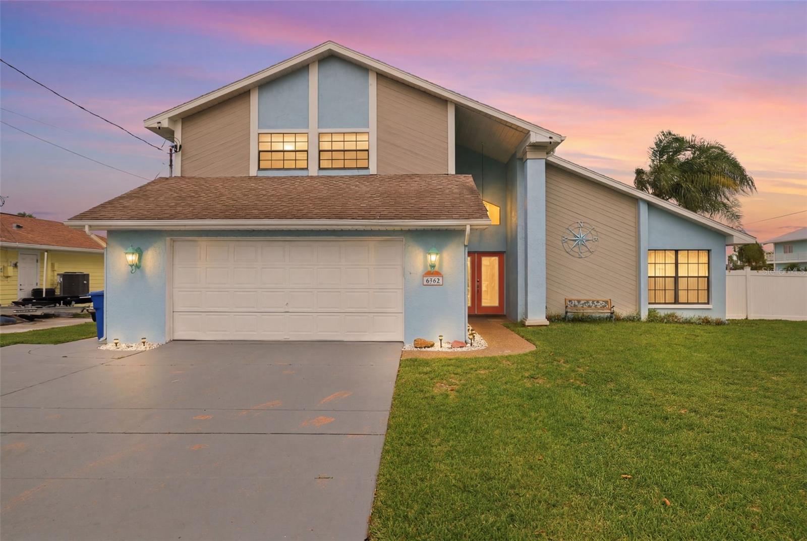Currently used as an income producing Airbnb (can be sold completely furnished) and perfectly positioned on a 0.19-acre canal-front homesite, this waterfront residence with 3 bedrooms, 2.5 bathrooms, and 2 car garage, offers direct access to the Gulf and is the ideal blend of comfort, space, and the laid-back coastal lifestyle Hernando Beach is known for. A charming blue exterior, expansive front lawn, and impressive two-story entry create a memorable first impression, while decorative glass double doors welcome you into a bright and inviting interior. Adding to the home's appeal, the water heater was updated in 2024. Inside, soaring ceilings and abundant natural light enhance the home's spacious feel. The living room is highlighted by a vaulted ceiling, exposed wood beam, tile floors, and oversized windows overlooking the front landscape, while the adjacent dining area provides an ideal setting for gatherings and offers direct access to the outdoor entertaining spaces. Adjacent to the kitchen, you'll find a thoughtfully designed built-in desk area featuring a granite counter, extensive cabinetry, crown molding, and ample storage. The beautifully updated kitchen serves as the heart of the home, also showcasing granite countertops, stainless steel appliances, white upper cabinetry paired with navy lower cabinetry, breakfast bar, tray ceiling with crown molding, and a bright breakfast nook perfect for casual dining. Toward the rear of the home, the family room is enhanced by elegant crown molding and sliding glass doors that open seamlessly into the Florida room, where walls of windows, showcase breathtaking canal views and fill the space with natural light. Whether relaxing with family or entertaining guests, these interconnected spaces create a seamless flow between indoor comfort and the waterfront scenery beyond. A convenient guest bath and dedicated laundry room complete the main level. The second-floor primary bedroom offers a private retreat with direct access to a waterfront balcony overlooking the canal. It also features a walk-in closet and an en-suite bathroom with dual vanities, abundant storage, and a step-in shower. Two additional bedrooms and a full guest bath provide comfortable accommodations for family and visitors. Step outside and experience the true highlight of the property. An expansive waterfront patio, covered gazebo, and above-ground pool create a backyard designed for entertaining and relaxation. The private floating dock has electricity and a fish cleaning station. The existing boat lift provide convenient access for boating, fishing, kayaking, and paddleboarding, while wide canal frontage offers quick and direct access to open waterways and the Gulf beyond. There’s also a custom-built boathouse/storage shed that matches the house, and a white vinyl fence around the rear yard. Thoughtfully designed to embrace its waterfront setting, this exceptional property delivers the Florida lifestyle so many dream about.