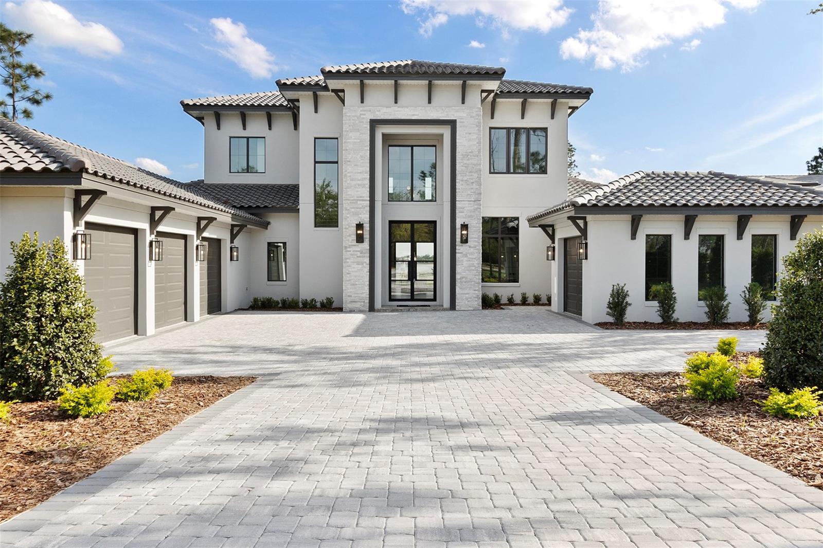 This stunning lakefront 2-story custom estate boasts 5 bedrooms, 6 bathrooms, and a split 4-car garage with southern backyard exposure and the opportunity for a private boat dock. Enter through grand double iron doors into a soaring 24' foyer with a striking glass balustrade staircase and custom wine cellar beneath. Engineered hardwood floors flow through the open-concept first floor, featuring a great room with tray ceilings and sliding doors that lead to a backyard oasis.

The great room, with tray ceilings, seamlessly transitions to the backyard through two sets of sliding glass doors, offering a perfect blend of indoor and outdoor living. The gourmet kitchen is a centerpiece, featuring wiht shaker-style and honey Carini cabinets with gold accents, a waterfall-edge island, and top-tier Fisher & Paykel appliances, including an 8-burner gas range, convection oven, and wine cooler. A spacious walk-in pantry off the kitchen ensures ample storage and organization.

The first-floor primary suite offers a serene retreat with private porch access overlooking the pool. The spa-like ensuite bath includes dual vanities, his-and-her toilets, and a freestanding tub elegantly enclosed within a walk-in shower. A custom-built walk-in closet and an additional closet provide versatile storage.

Rounding out the lower level is a thoughtfully designed office, ideal for those who work from home. A functional mudroom and laundry room add convenience, while a hidden guest suite, cleverly tucked behind a pass-through door in the kitchen, offers privacy and comfort for visitors. The expansive game room is an entertainer’s dream, featuring tray ceilings, a wet bar, and sliding glass doors lining two sides of the space. Pocket sliders open seamlessly to the outdoor entertaining area, where a travertine-tiled summer kitchen awaits.

Upstairs, three generously sized bedrooms each include ensuite baths and walk-in closets. An open loft offers a flexible space, with both the loft and one of the bedrooms providing access to a covered balcony overlooking the pool. The backyard is a true oasis, featuring a rectangular infinity-edge pool with a sun shelf and an integrated spa for year-round relaxation. This home is the perfect blend of luxury, functionality, and resort-style living.

The Club at Bella Collina provides year-round culinary experiences and social events for all ages. Play a round of golf on the Nick Faldo-designed course or unwind on one of the scenic restaurant terraces. Additional amenities include lighted Har-Tru tennis courts, pickleball courts, an outdoor pool complex, and a spa and fitness center offering a variety of complimentary fitness classes. Contact us today to discover more about this exceptional home in Bella Collina!